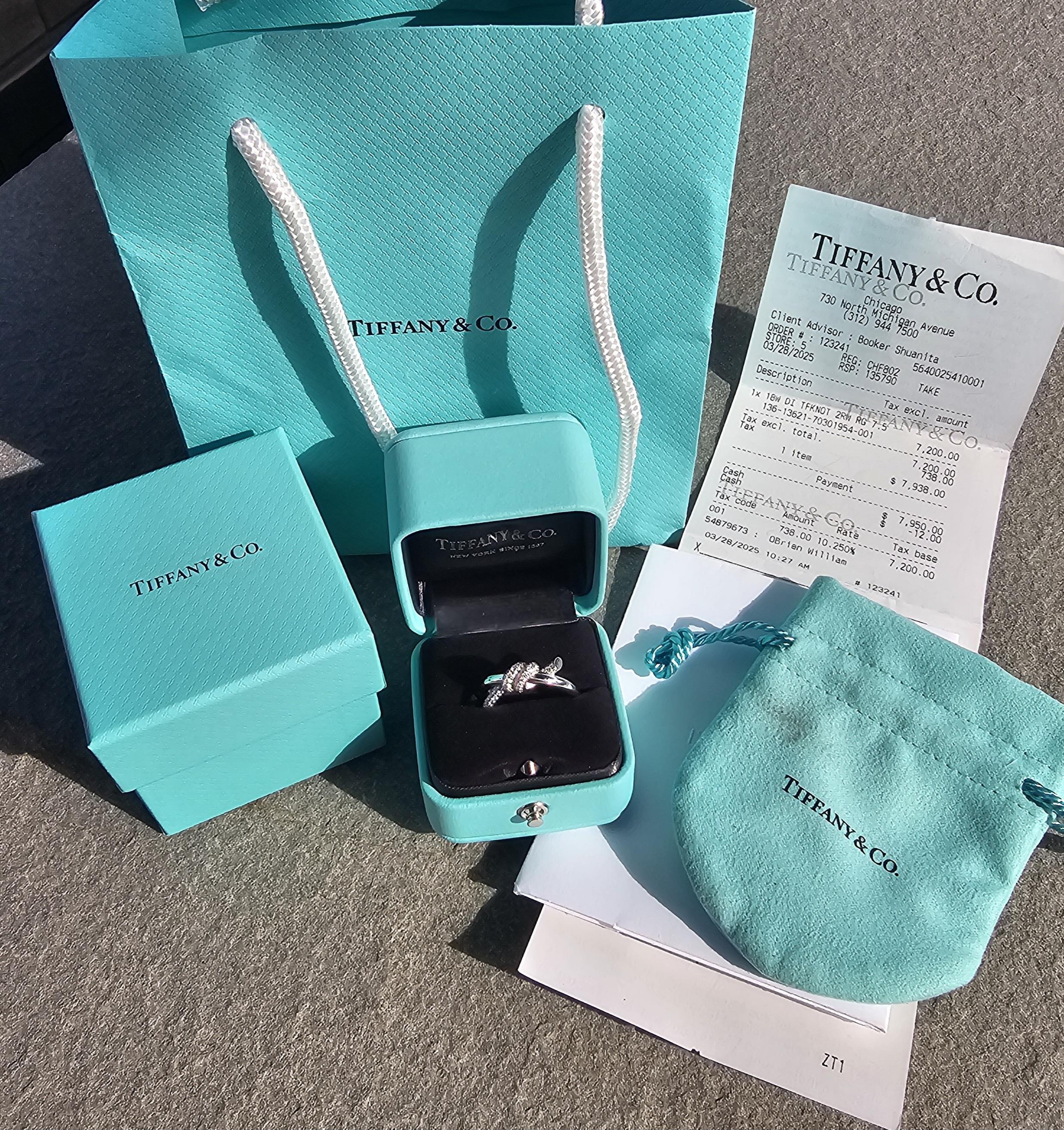 Cette élégante bague Tiffany & Co. est une pièce de joaillerie captivante. Fabriqué en or blanc 18 carats, il présente un motif de nœud unique orné de diamants blancs. La bague est disponible en taille 6,5 et convient parfaitement aux personnes qui
