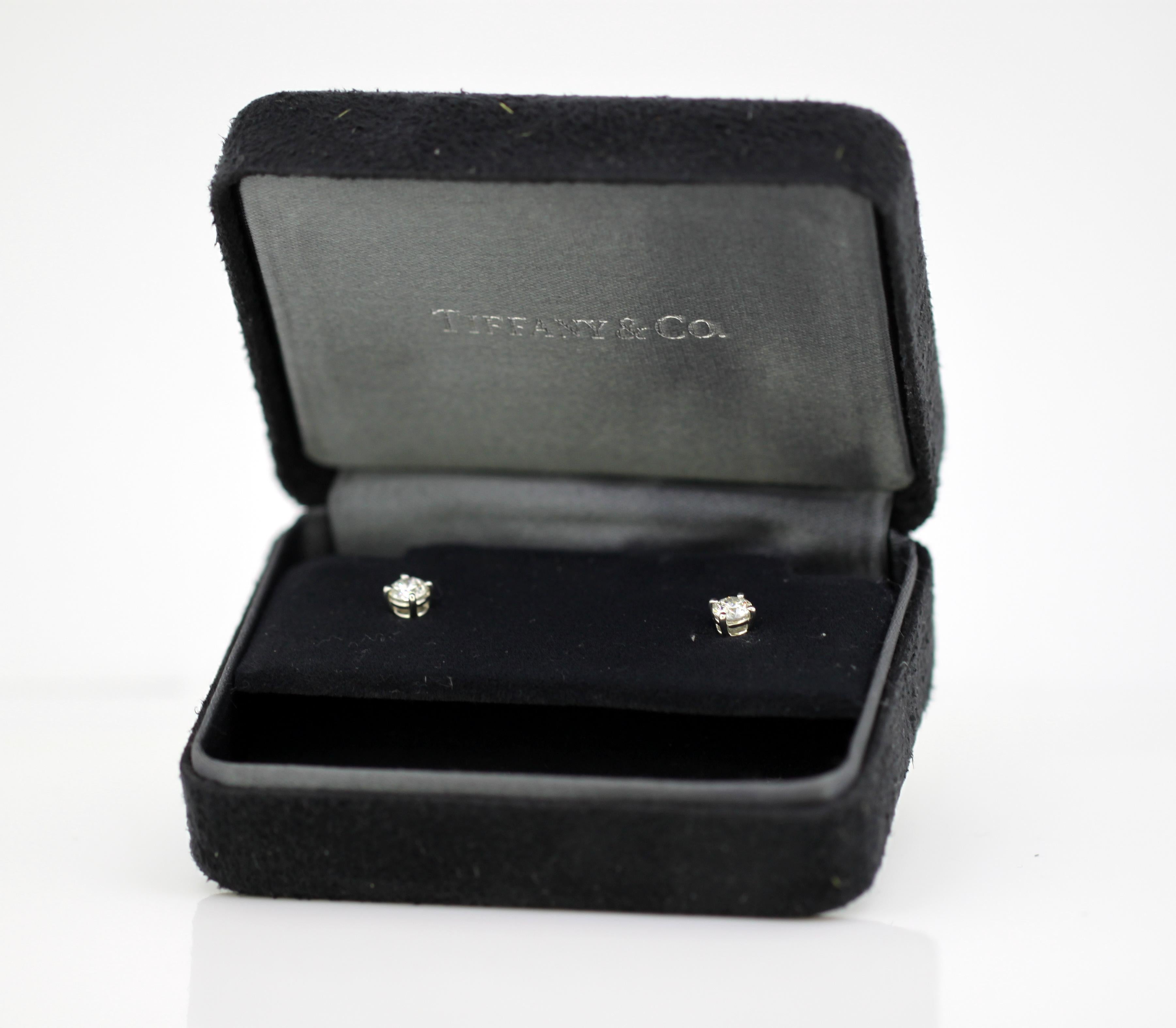 Ladies platinum stud earrings with diamonds. 
Designer : Tiffany & Co 
Made in London 2012 
Fully hallmarked. 

Approx Dimensions - 
Earring Size ( Length x Width ) : 1.5 x 0.6 cm 
Weight: 2 grams 

Diamond - 
Cut : Brilliant 
Colour : E/F 
Clarity