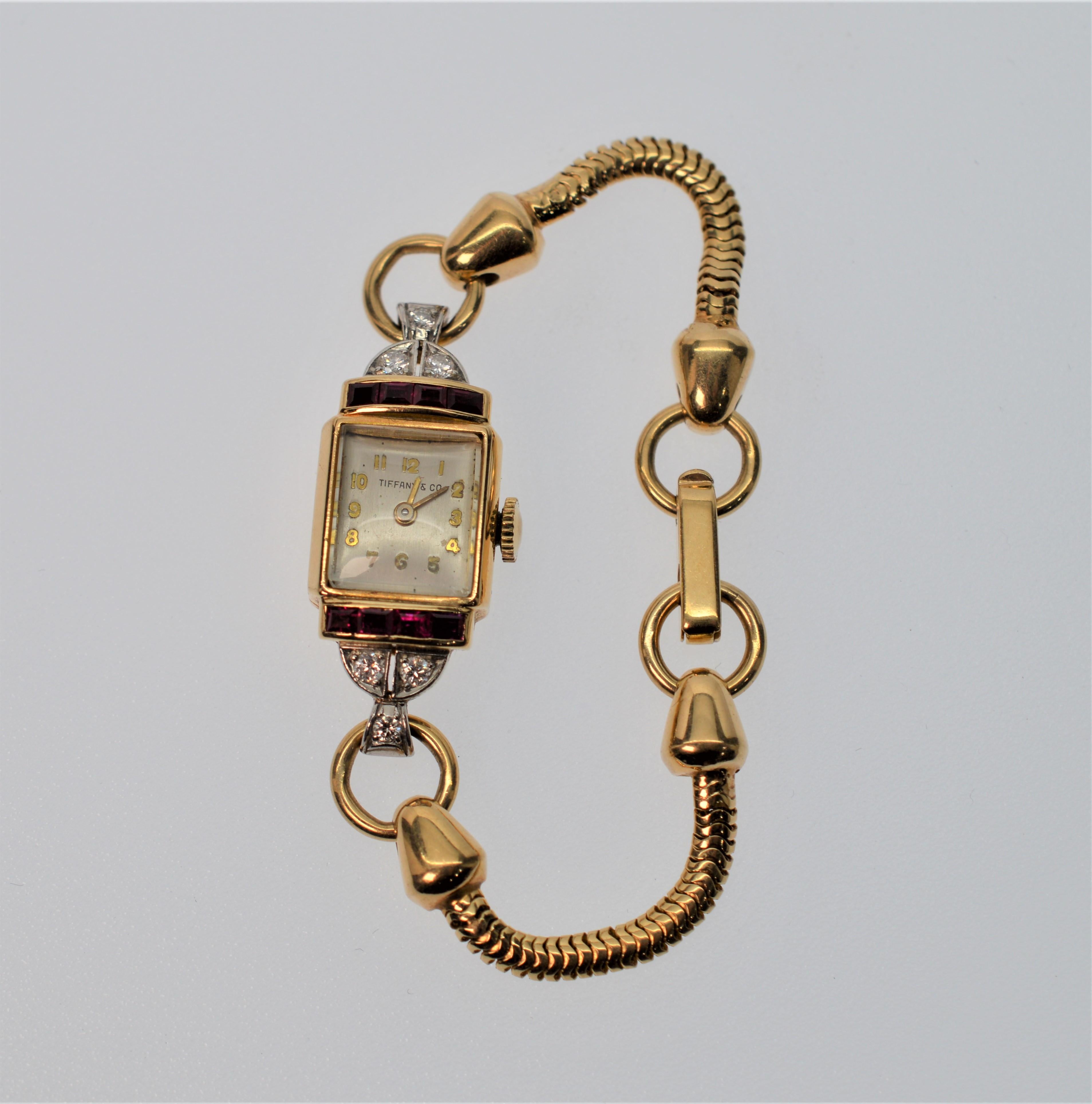 Tiffany & Co. Ladies Ruby & Diamond 14k Yellow Gold Watch Bracelet. In working order, this 17 jewel watch has a movement by Crestwood Watch Co.
The watch head measures approximately 1-1/4 x 1 inch and is inlaid with eight Rubies (.40 cts. total