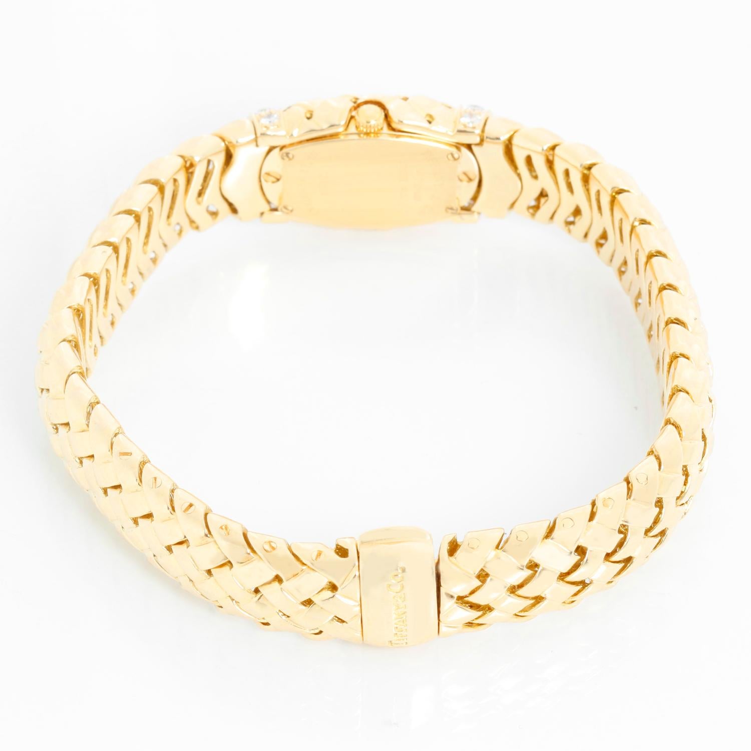 Tiffany & Co. Ladies Vannerie 18K Yellow Gold Watch 12.0504 - Quartz. 18K Yellowy gold case with diamond bands on each end of watch ( 15 x 22mm); Sixteen diamonds total. White dial with gold Roman numerals at 12, 3, 6 and 9; Signed Tiffany & Co..