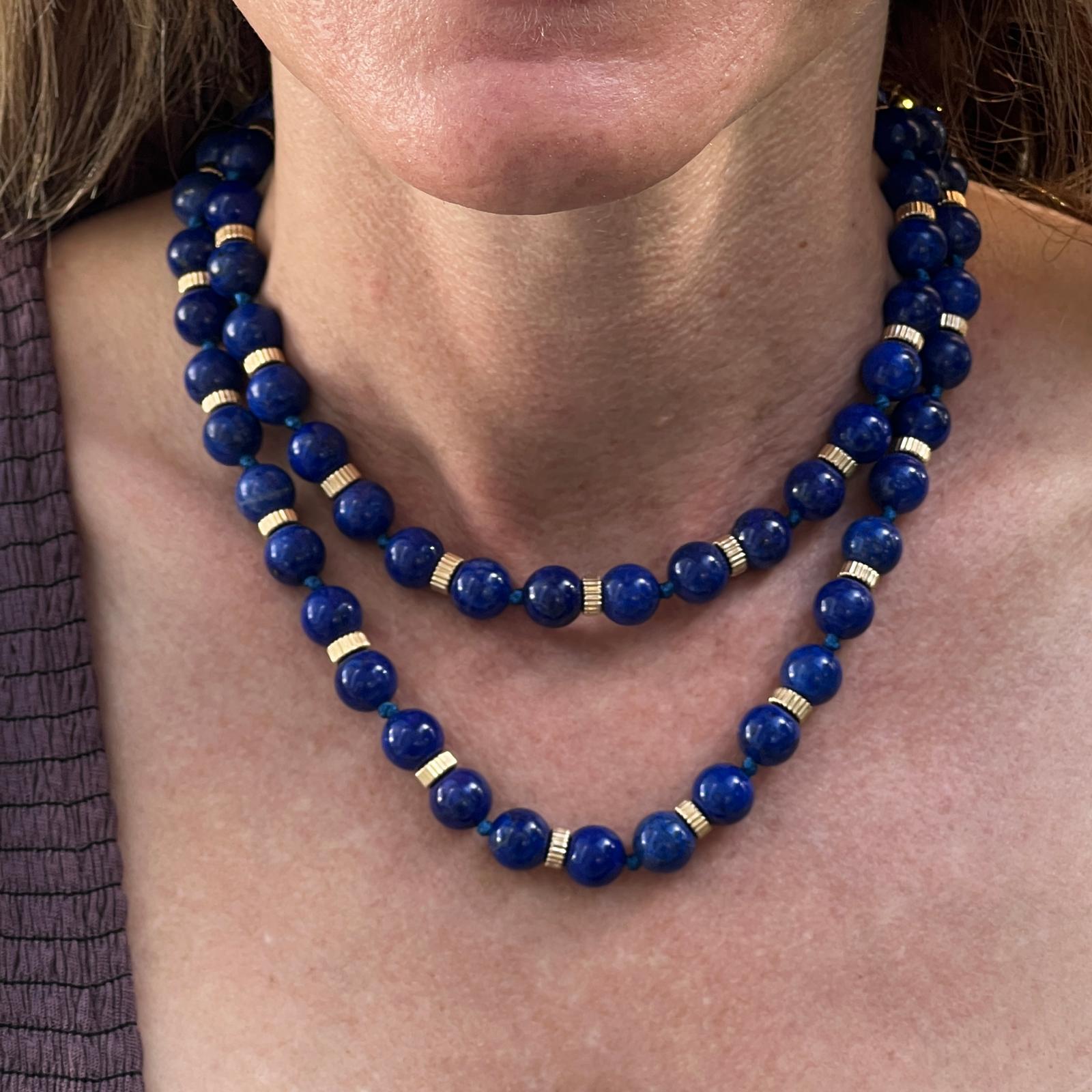 Authentic Tiffany & Co. Lapis Lazuli bead necklace fashioned in 18 karat yellow gold. The 32 inch necklace can be worn long or doubled. The beads measure approximately 10mm, and the gold rondels are ribbed. Clasp with safety signed T&Co. 18K. 