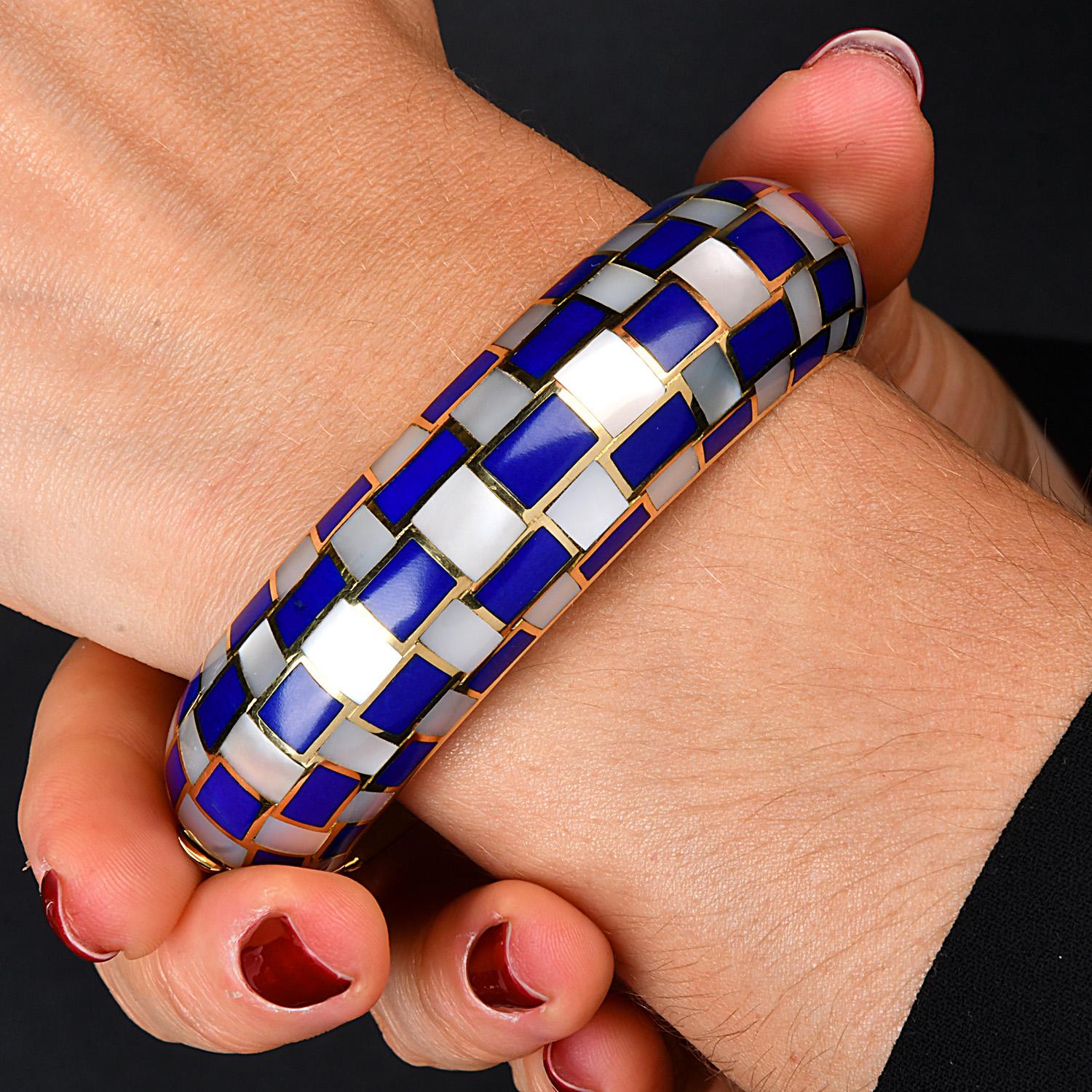 Tiffany & Co. 18K Yellow Gold lapis lazuli  & Mother of Pearl Grid Bangle Bracelet. Crafted in 18K yellow gold, this bracelet features a unique woven grid pattern adorned with vibrant blue enamel and luminous mother-of-pearl inlay. The intricate