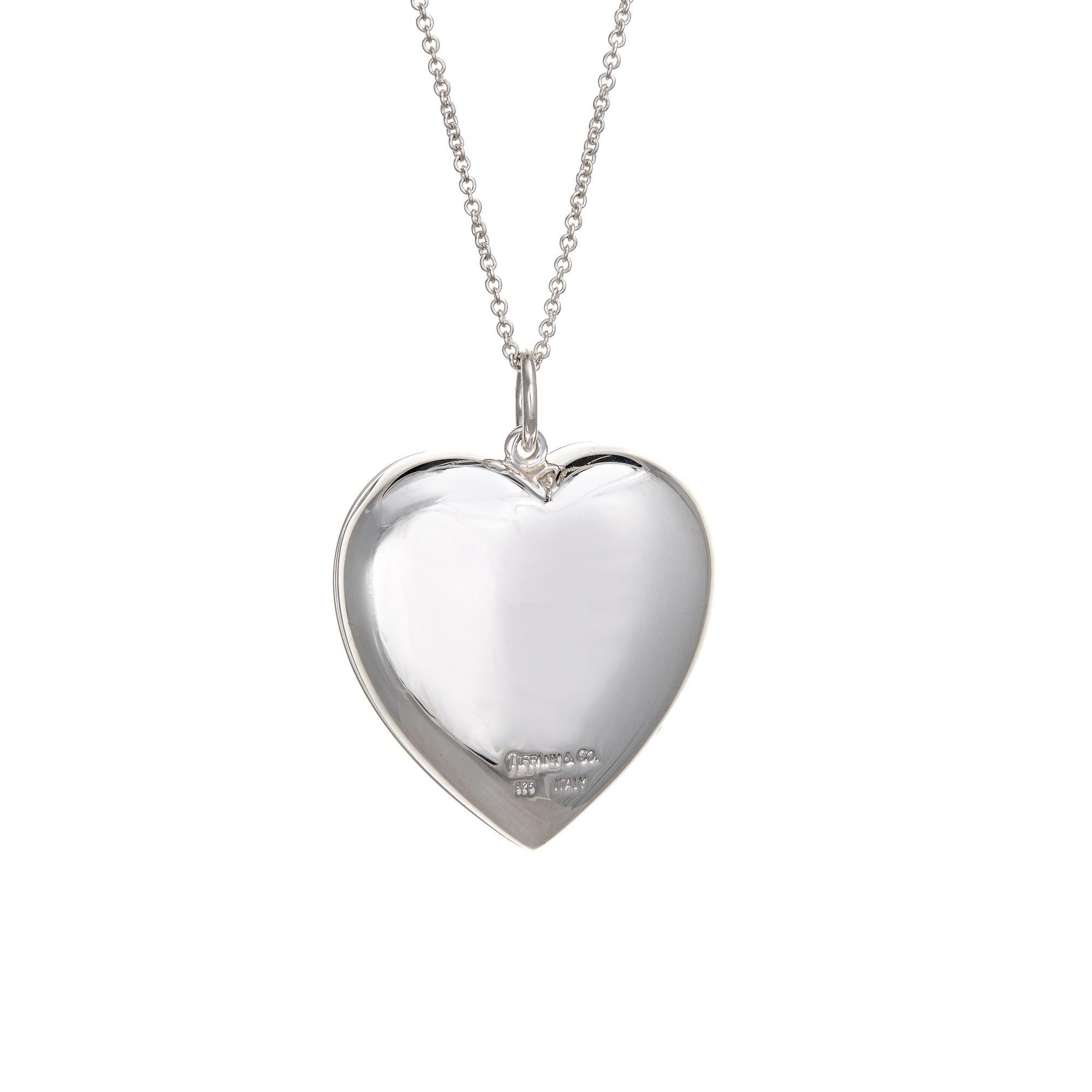 Elegant and finely detailed vintage Tiffany & Co sterling silver heart locket + necklace.  

The puffed heart is large in scale (1.45 inches) and open to accommodate a photo or keepsake. Also included is the fine link Tiffany & Co chain measuring 16