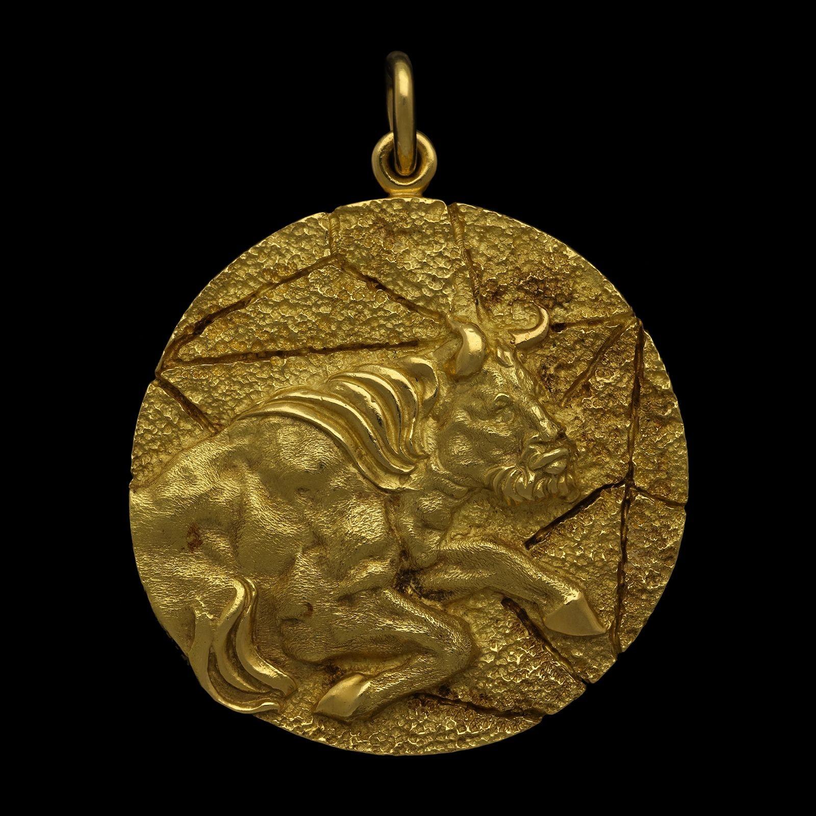 A large vintage Taurus zodiac pendant by Tiffany & Co, circa 1970s, the circular disc pendant measuring 1.75” in diameter and formed of 18ct gold with a textured finish, on one side it depicts the front half of a rearing bull in profile in high
