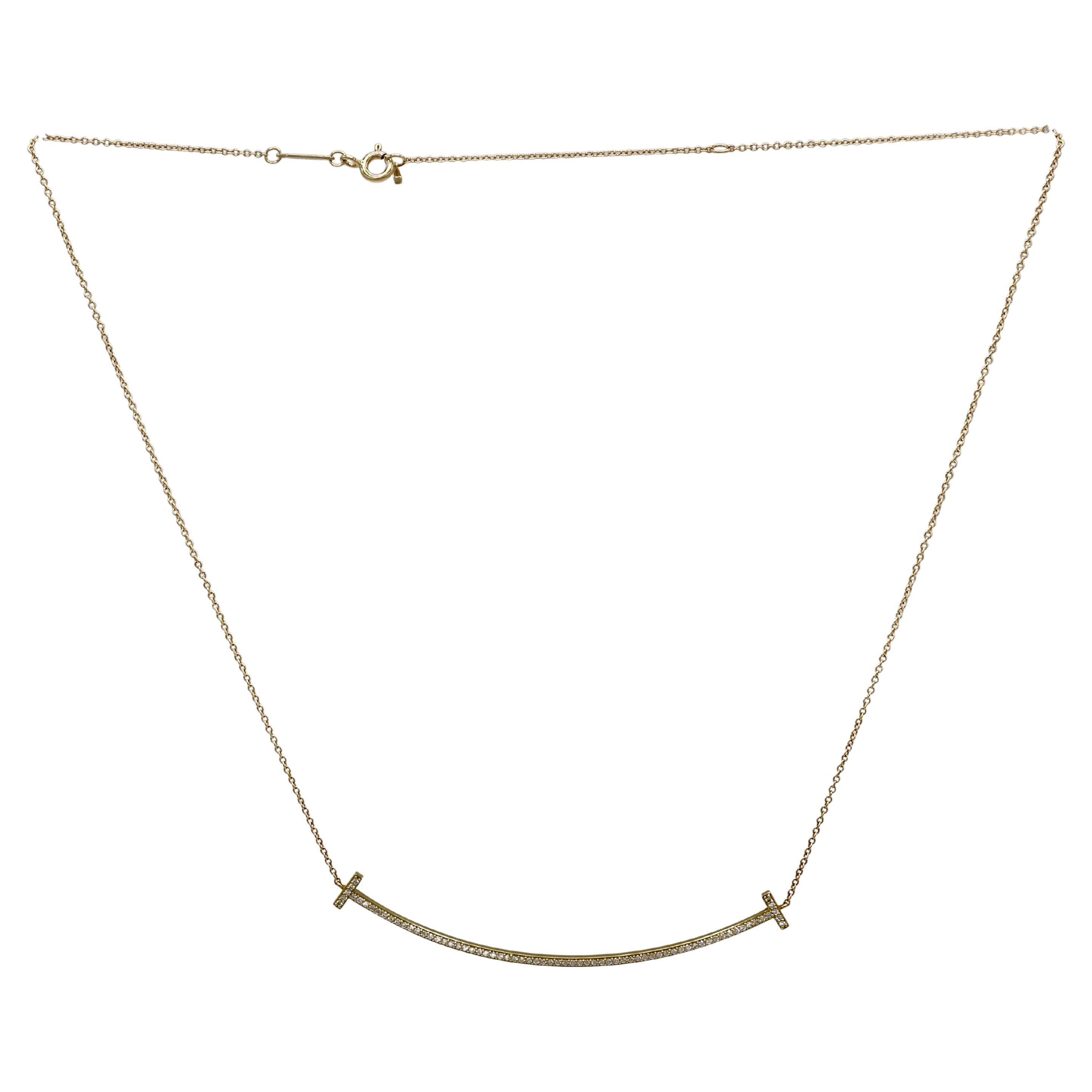 Tiffany & Co. Grand collier pendentif Tiffany T. Smile en diamant naturel or jaune 18K 
Métal : or jaune 18k
Poids : 4.41 grammes
Diamants : 0.19 CTW diamants ronds naturels F-G VVS
Pendentif : 69mm
Chaîne : chaîne réglable de 16 à 18 pouces
Signé :
