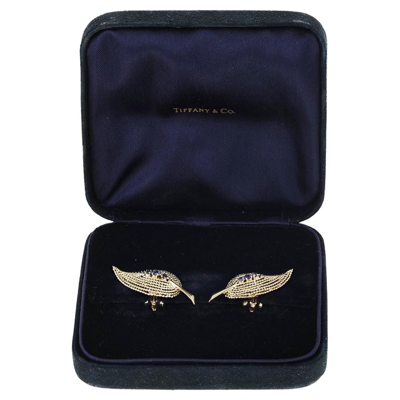 A pair of beautiful Tiffany & Co. Leaf 14k Gold and Sapphire Earrings. The earrings comes with a Tiffany & Co. Box. The total weight of the earrings is 7.30 grams. Horizontally, the earring is 1.50 inches. The earrings are clip-ons. 

