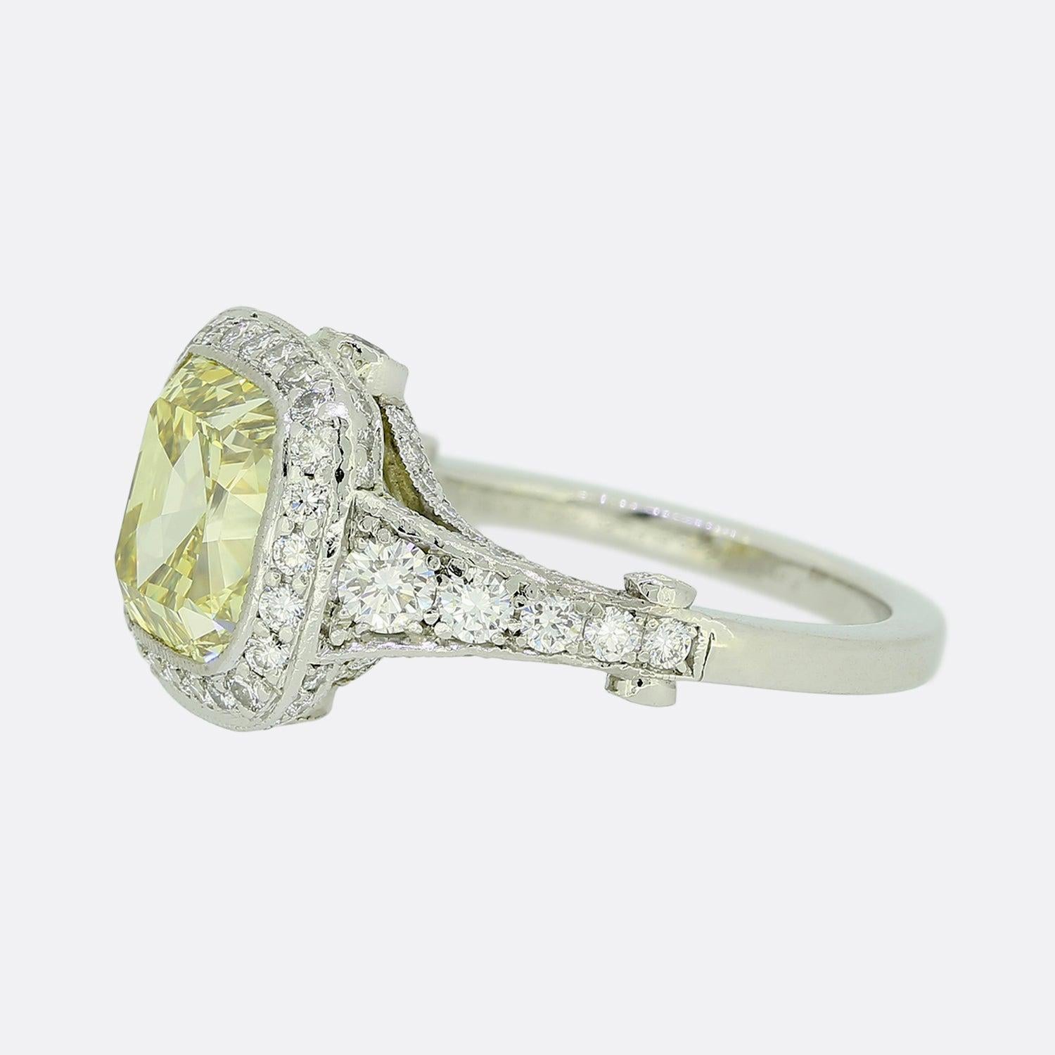 Here we have a shimmering diamond engagement ring from the world renowned jewellery designer, Tiffany & Co. The ring presents a 4.0 carat cushion-cut centre stone that is fancy intense yellow and VS1 clarity. It is surrounded by a single halo of