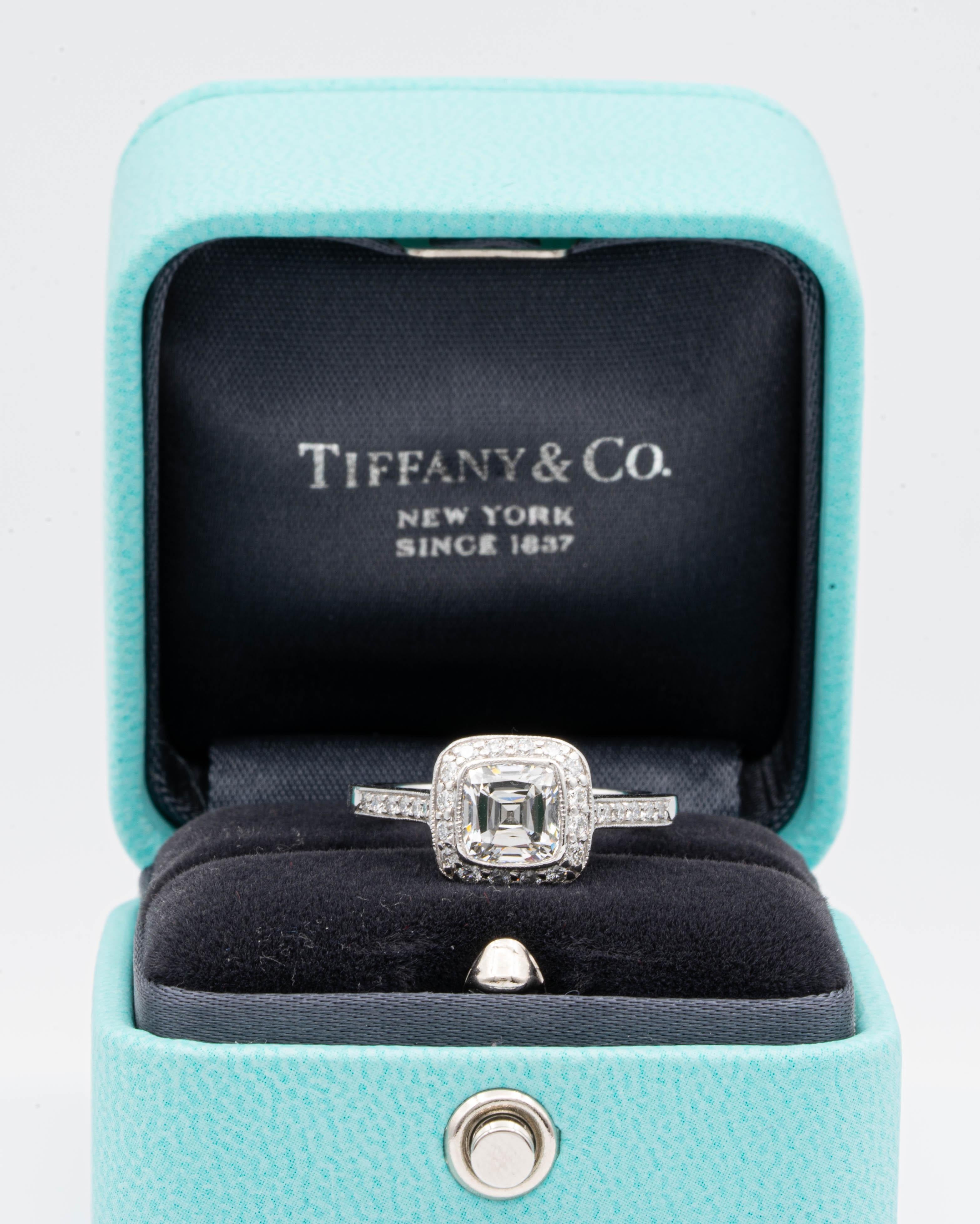 Tiffany & Co Cushion Brilliant Engagement Ring from the “Legacy” collection featuring a 1.22 carat center, G color, VS2 clarity, finely crafted in Platinum featuring dazzling bead-set diamonds in a full bezel millgrain design halo and half-way down