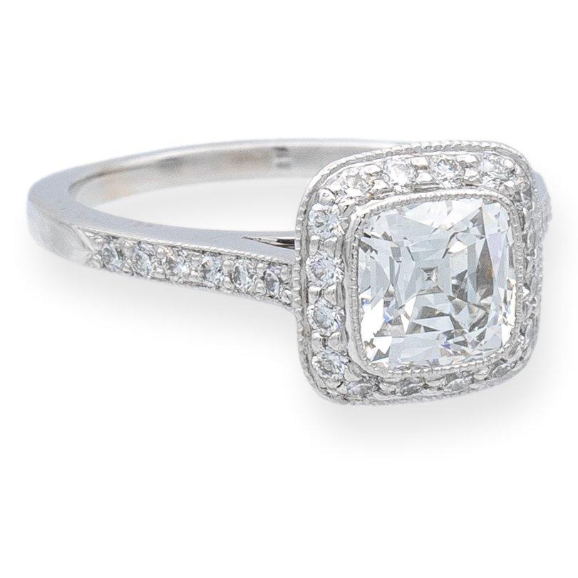 Tiffany & Co. Engagement Ring from the “Legacy” collection featuring a 1.23 carat center, H color, VVS1 clarity, cushion brilliant diamond finely crafted and set in platinum featuring dazzling bead-set diamonds in a full bezel millgrain halo and