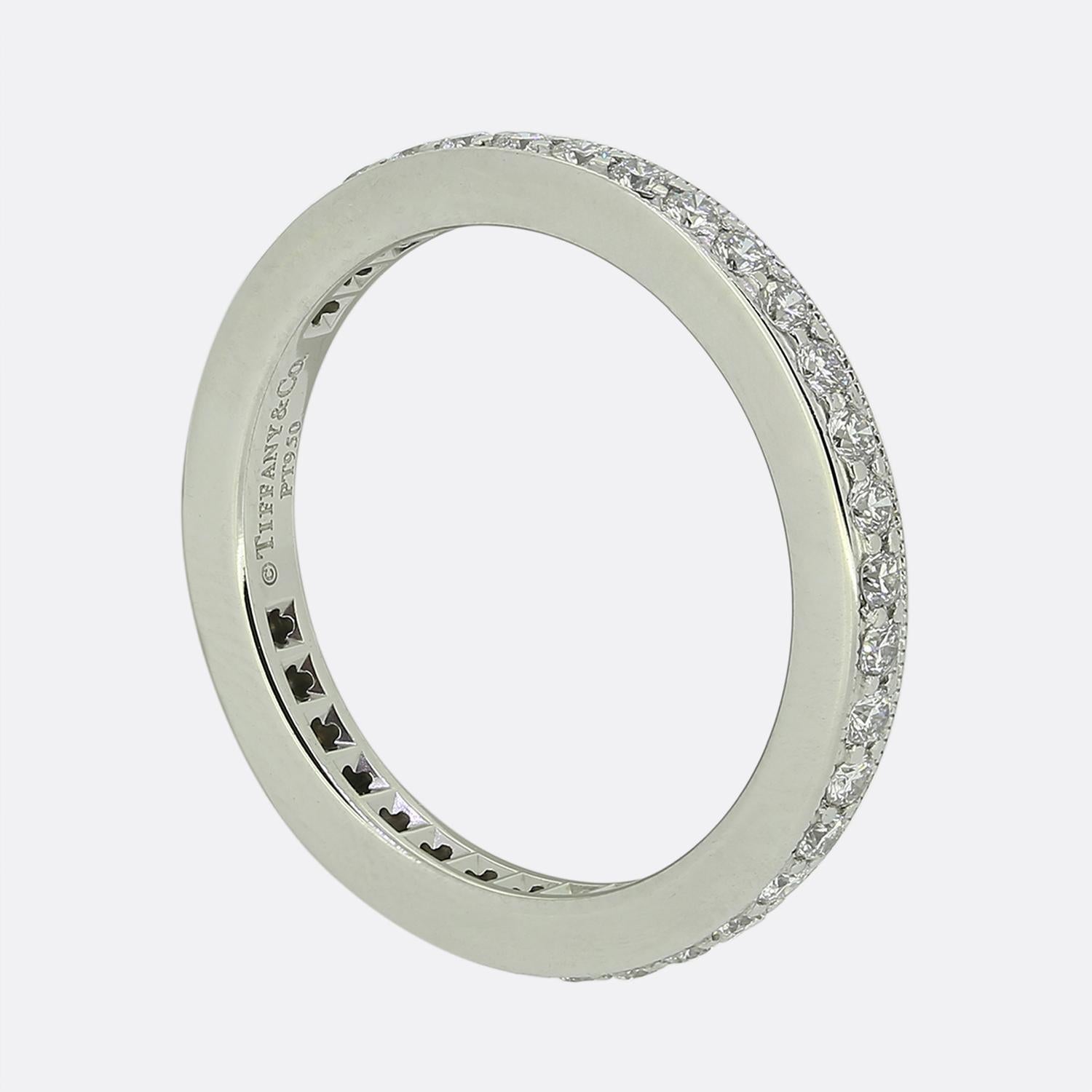 This is a platinum Tiffany & Co. diamond full eternity ring. The ring features 0.36 carats of round brilliant cut diamonds which spread the whole way around the band. The edges of the ring feature small milgrain detail with the piece forming part of