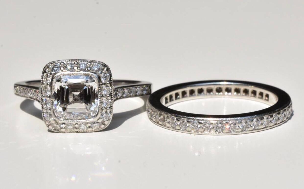 A Tiffany & Co diamond ring from the 'Legacy' collection set in Platinum. The ring features a central cushion-cut diamond of approx 1.19 carat with a surround of brilliant-cut round diamonds totalling approx .30 carats.

Current Tiffany & Co retail
