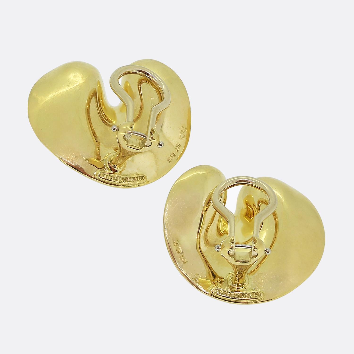 Ecco un paio di straordinari orecchini di Tiffany & Co., gioielliere di fama mondiale. Realizzati in oro giallo 18 ct, questi orecchini presentano un design audace e astratto con curve morbide e fluide che creano un look moderno e scultoreo che