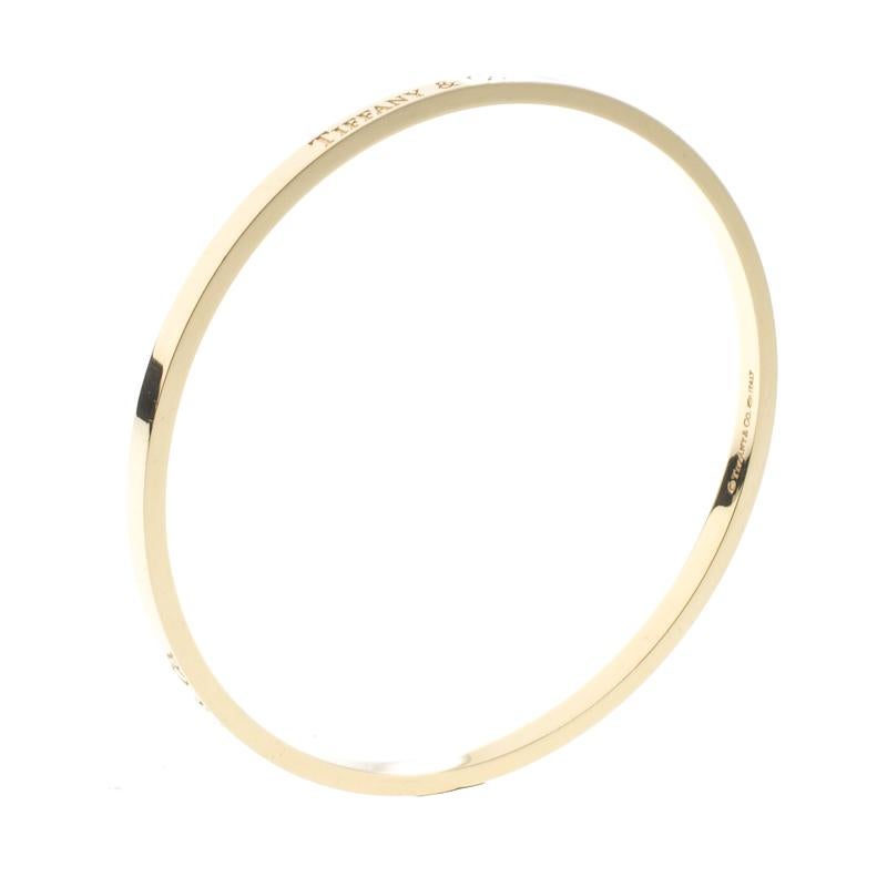 Diese Tiffany & Co. ist ein Traumkauf, denn sie schmiegt sich um Ihr Handgelenk und strahlt Schönheit aus. Er ist aus 18-karätigem Gelbgold gefertigt und mit dem Tiffany-Logo graviert, ein Design, das mit Präzision und Sorgfalt umgesetzt wurde. Das