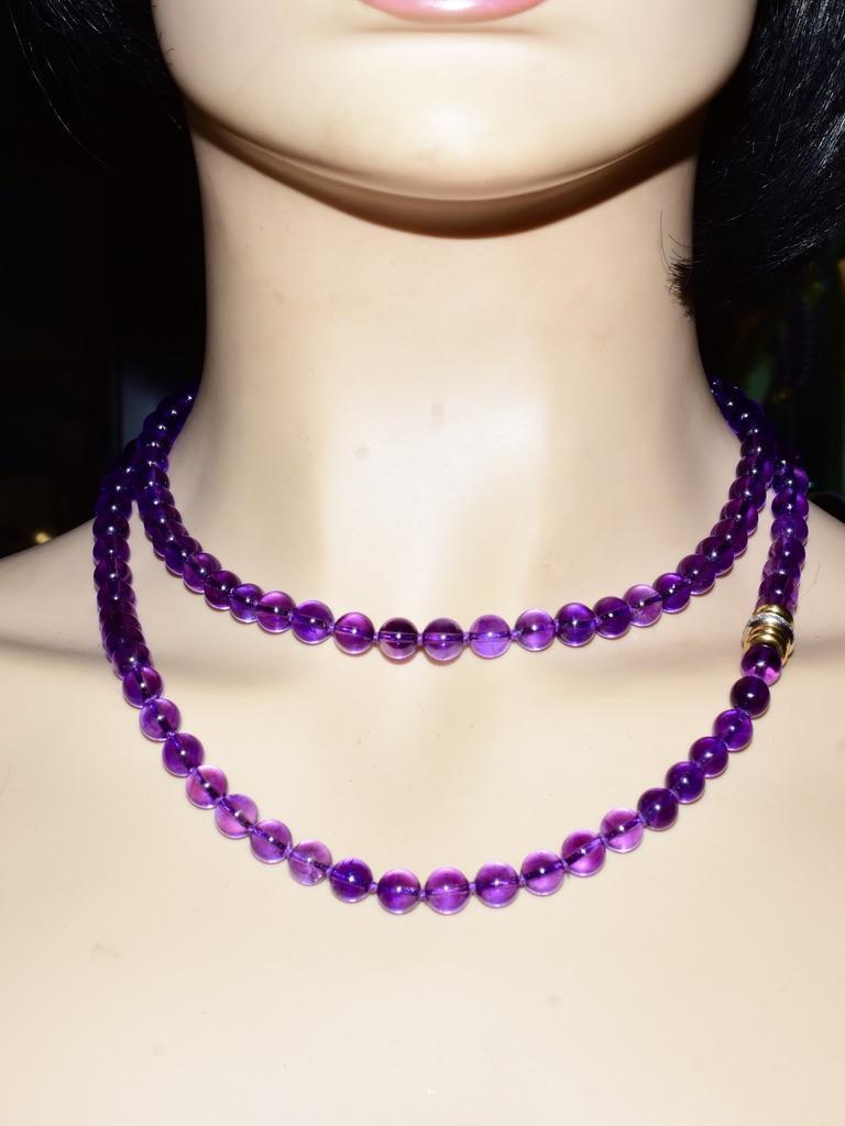 Gem quality round well matching natural clean, with a royal purple color, amethysts measuring approximately 8 mm. and 39 inches in length.  The barrel type clasp with round white brilliant cut diamonds is signed T & Co for Tiffany & Co., 750 for