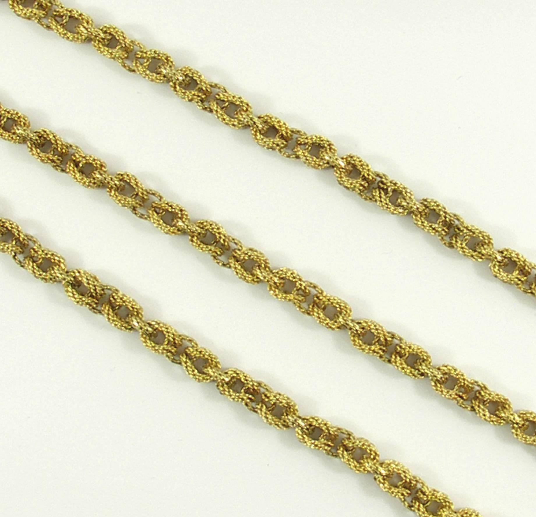 An 18K yellow gold necklace measuring 36 inches long, comprised of alternating lark's head loops, and connectors. Measuring 1/4 inch wide the three dimensional links, combined with the texture create a rich look. Signed Tiffany & Co., the overall