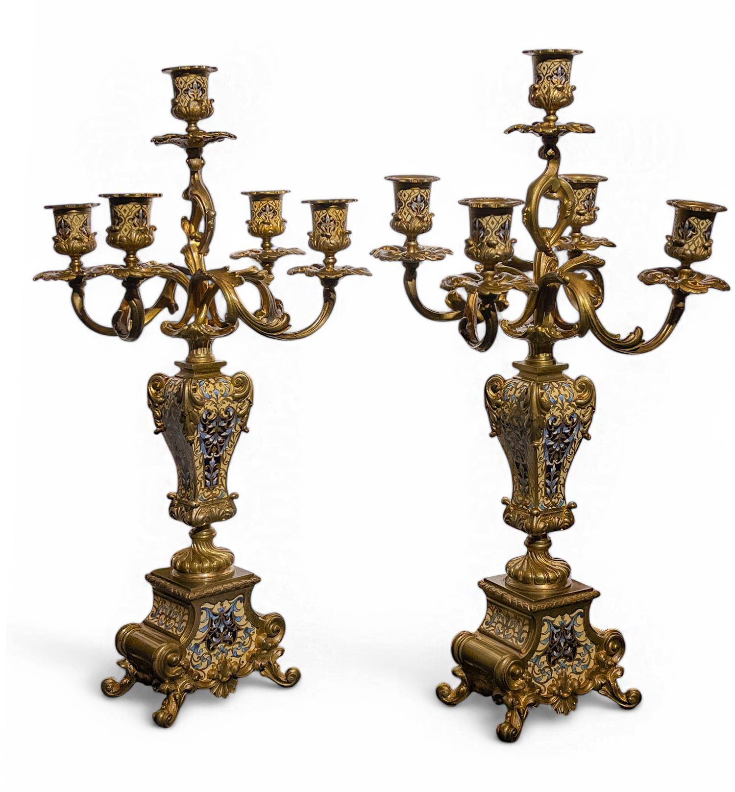 Tiffany & Co., Louis XV-style Champleve Clock Set

This ornate champelve set features blue and custard enamel in a floral pattern, framed by cast scrolls and foliate motifs. The central clock is topped by a putto holding a garland. Stamped