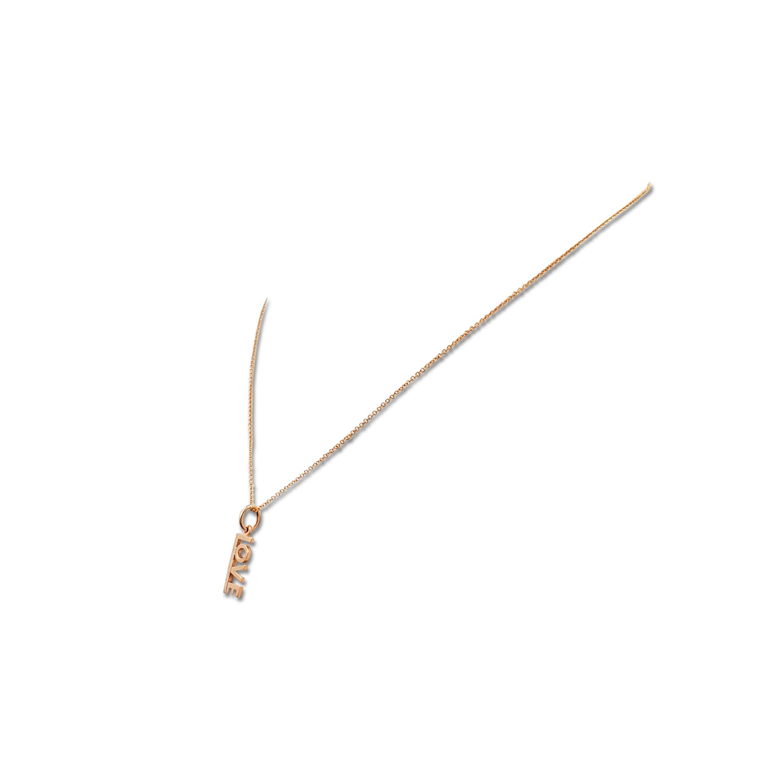 Authentic Tiffany & Co. pendant necklace crafted in 18 karat rose gold. The charming pendant spells out the word 'LOVE' and hangs from a delicate rose gold chain. Signed T&Co., 750. The necklace is presented with the original pouch, no box or