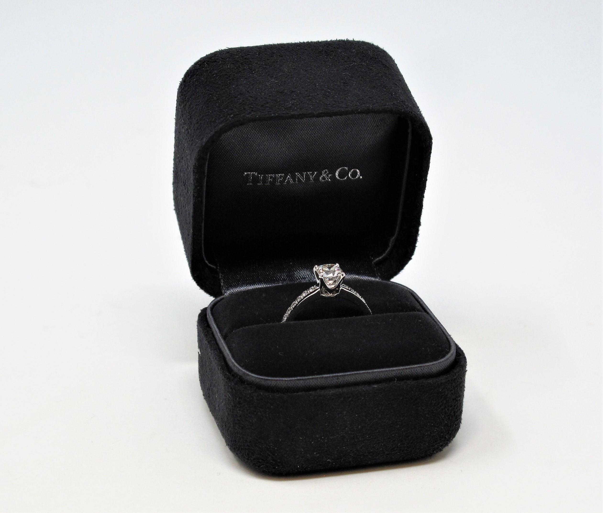 Say yes to this incredible diamond solitaire engagement ring from Tiffany & Co.! The classic style engagement ring gets a modernized update with this unique Lucida cut center diamond accented by a glittering pave diamond shank. Popping the question