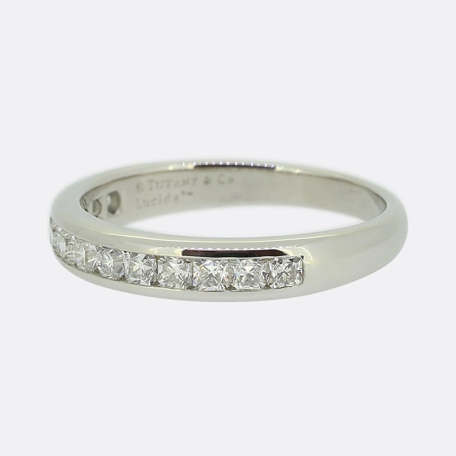 Aquí tenemos un anillo clásico de medio diamante de los mundialmente conocidos diseñadores de joyas Tiffany & Co. Esta pieza se ha elaborado en platino y luce trece diamantes talla Lucida engastados por frotamiento, la emblemática talla patentada de