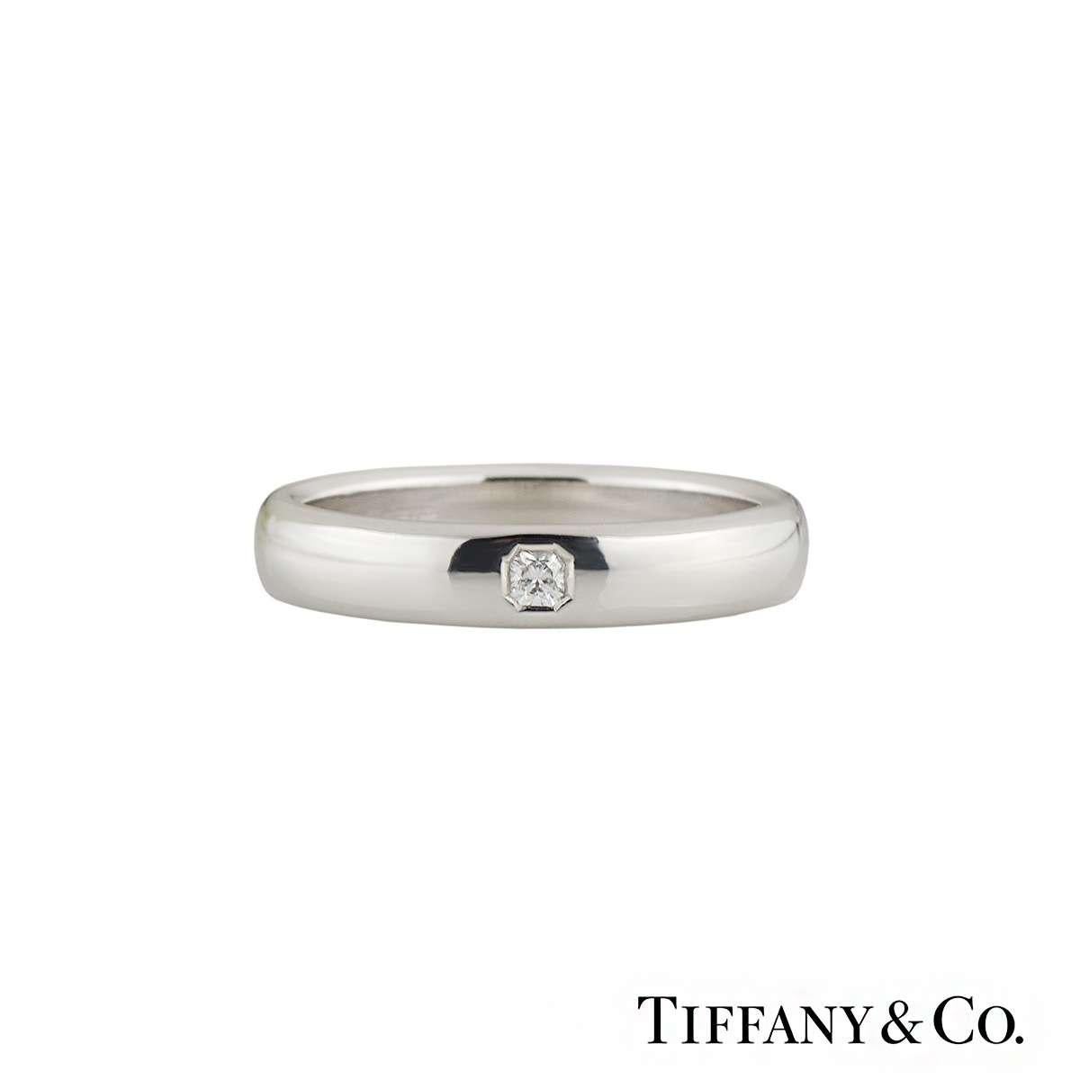 An elegant Tiffany & Co wedding band in platinum from the Lucida collection. The ring has a lucida cut diamond in a tension setting with a total weight of 0.05ct, G colour and VS2 clarity. The ring features a highly polished 4mm court fit band. The