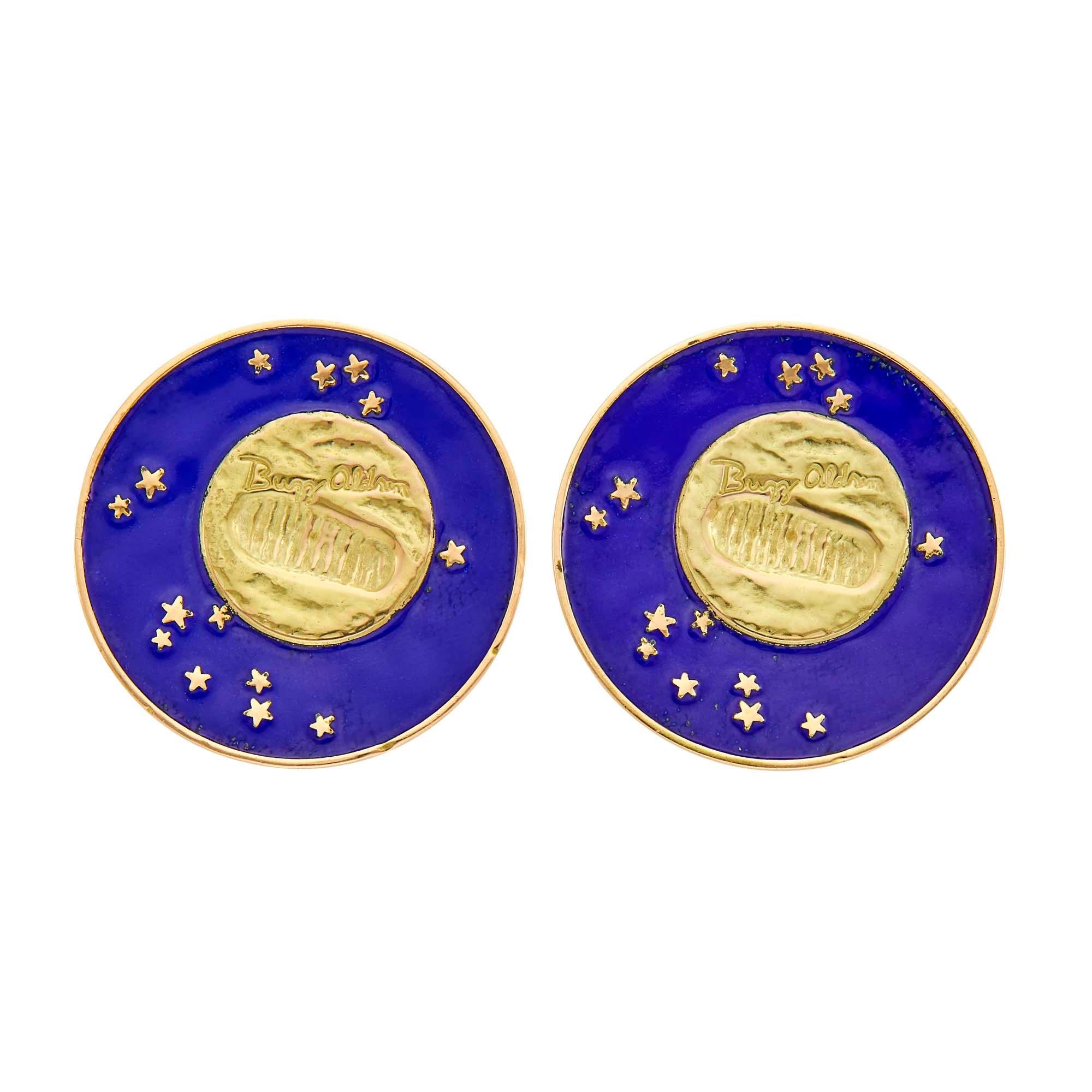 A fun pair of “Lunar Landing” earclips, each centering a commemorative coin with Buzz Aldrin’s signature and footprint in a circular frame of blue enamel and gold stars, signed Tiffany & Co.