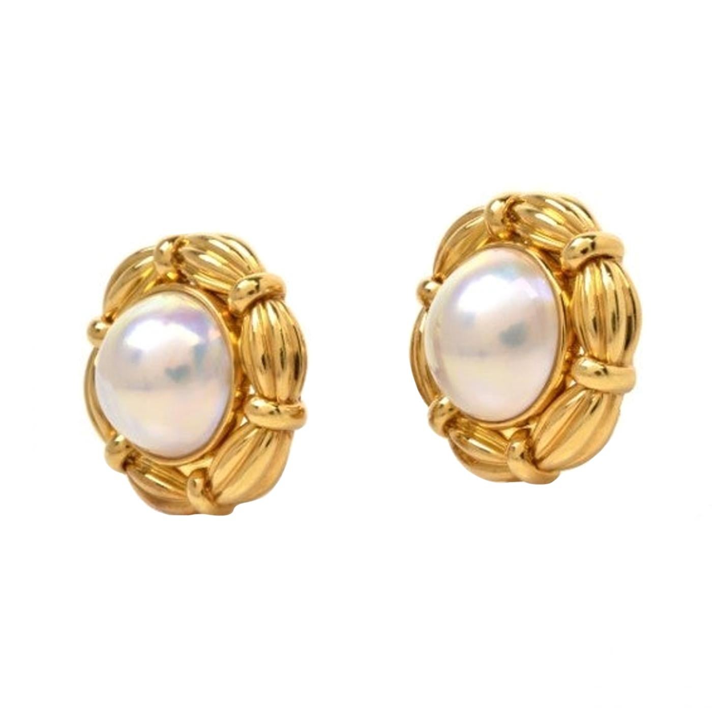 These estate authentic Tiffany & Co. earrings are crafted in solid 18K yellow gold and weigh approximately 30.4 grams. In an alluring floral design, these earrings are centered with a duo of iridescent Mabe pearls, measuring approx. 30mm in diameter