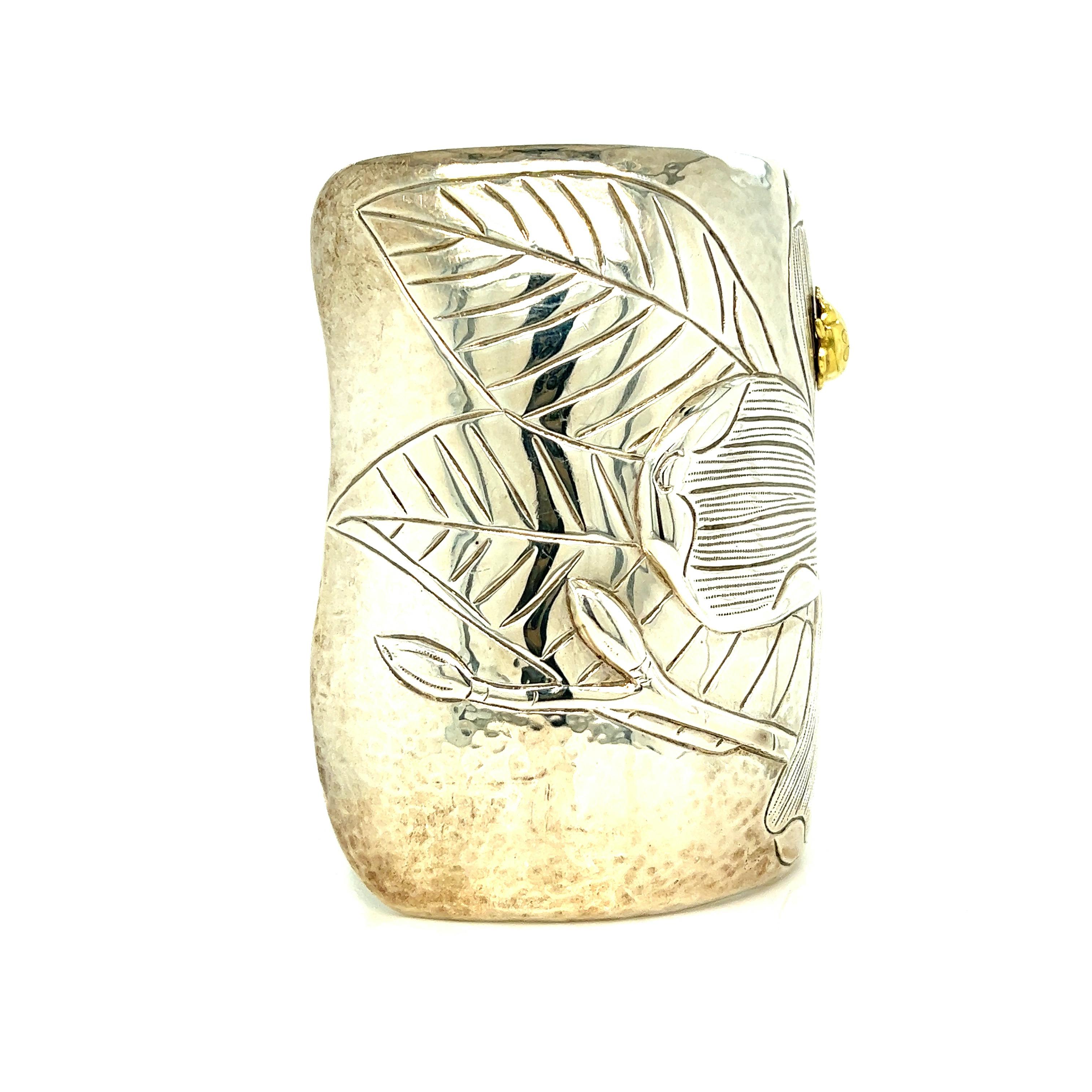 Tiffany & Co. magnolia and ladybug cuff bracelet

Large model, sterling silver and 18 karat yellow gold; marked 2000, Tiffany & Co., 925, 750

Size: width 3 inches, inner circumference 7 inches
Total weight: 178.1 grams 