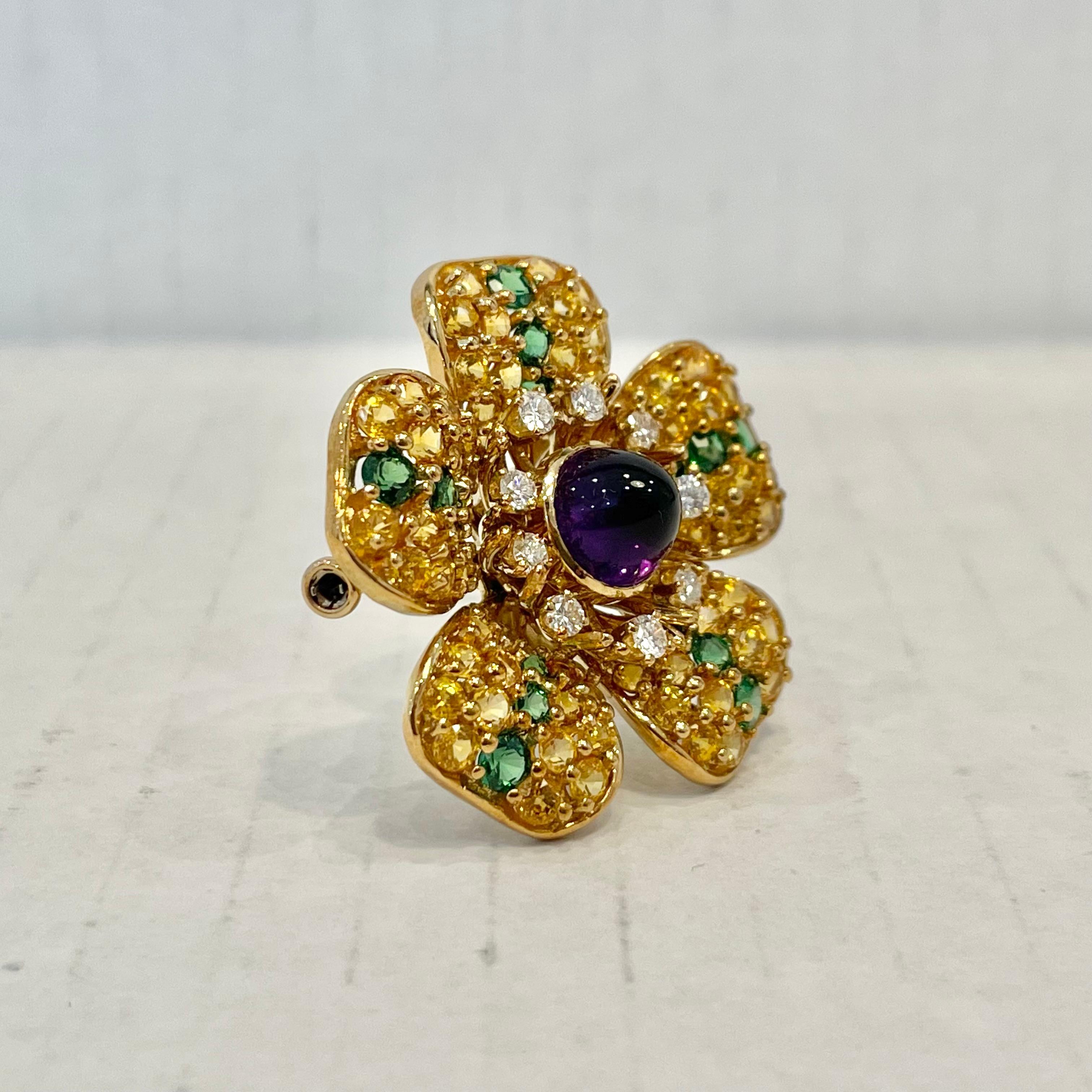 Elegant Tiffany & Co. Magnolia pin in 18k yellow gold and completely covered in gems. This pin is decorated with 80 yellow sapphires weighing 5.92 carats, 9 brilliant cut diamonds weighing .44 carats, 15 round faceted tsavorites weighing 1.60 carats