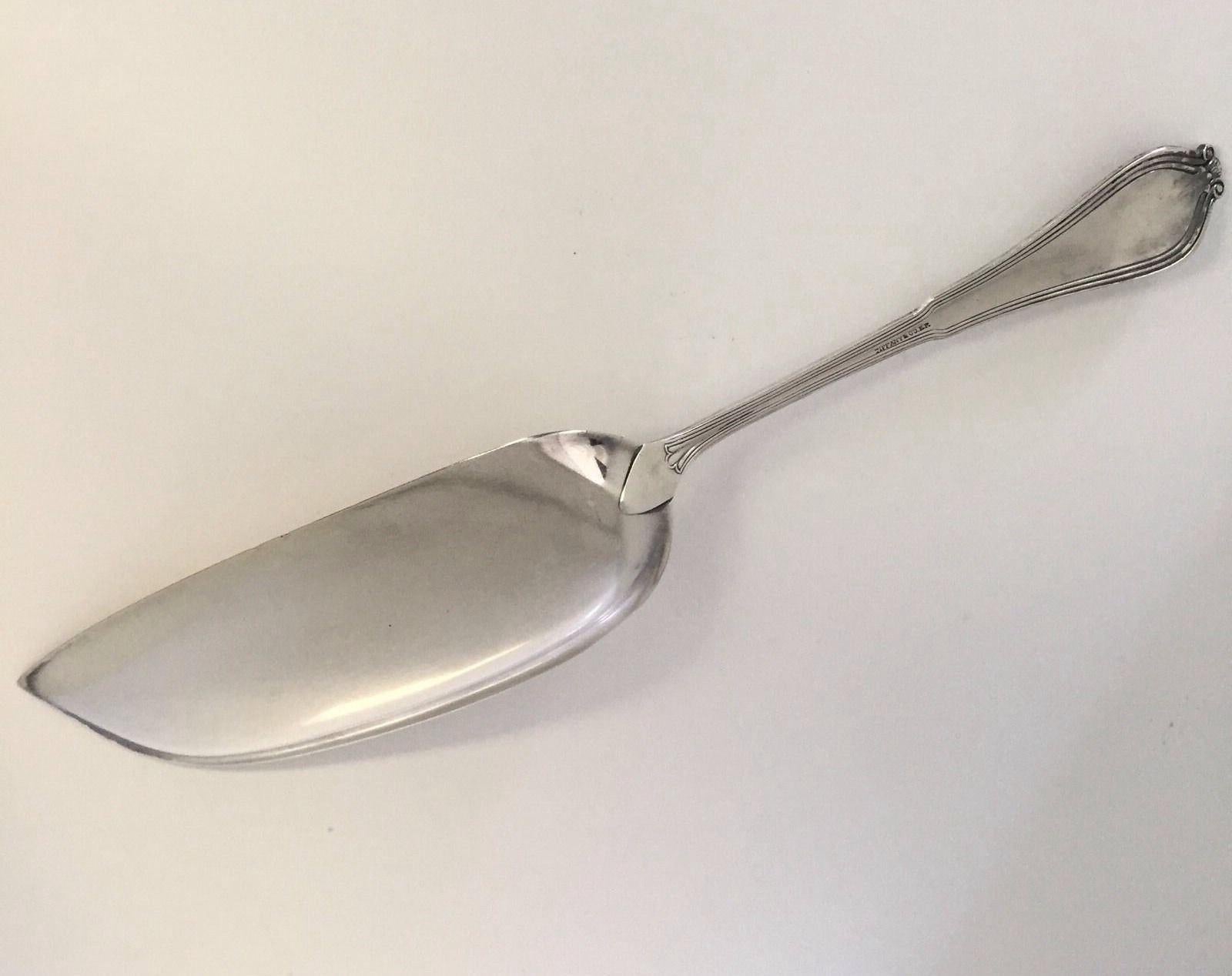 Tiffany & Co. silver plated EP large flat handle crumb knife/ crumber. 
In this Whittier 1907 pattern. 
Monogram of DB. 
Marked: TIFFANY & CO. E.P. 
Measures: 13 1/8