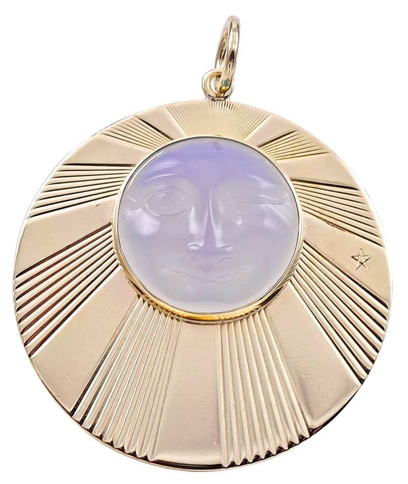Large round charm/pendant, with radiating line pattern.   Applied is a large moonstone, with a carved 