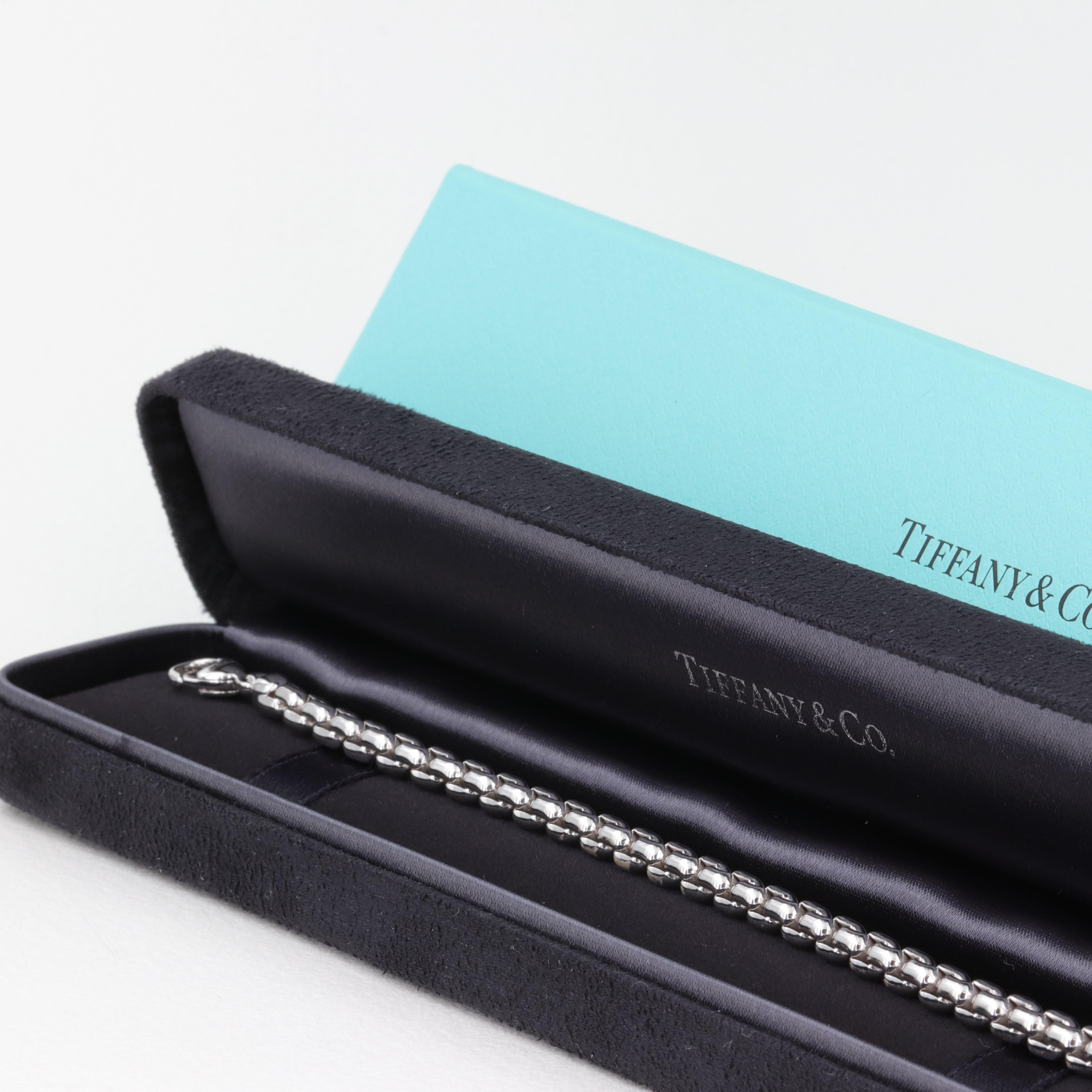 A finely crafted 18 karat white gold box link bracelet by Tiffany & Co.

This bracelet features solid links with and interlocking design that wears comfortably on the wrist alone while also perfectly accenting a watch. 

The bracelet measures 8.4