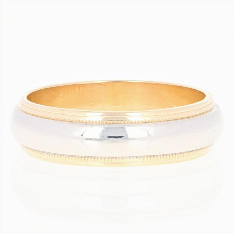 Handsome and refined, this wedding band will be an excellent choice for your groom! This 18k yellow gold ring by Tiffany & Co. showcases a luminous 950 platinum band that wraps around the center of the band and is framed by high purity gold milgrain