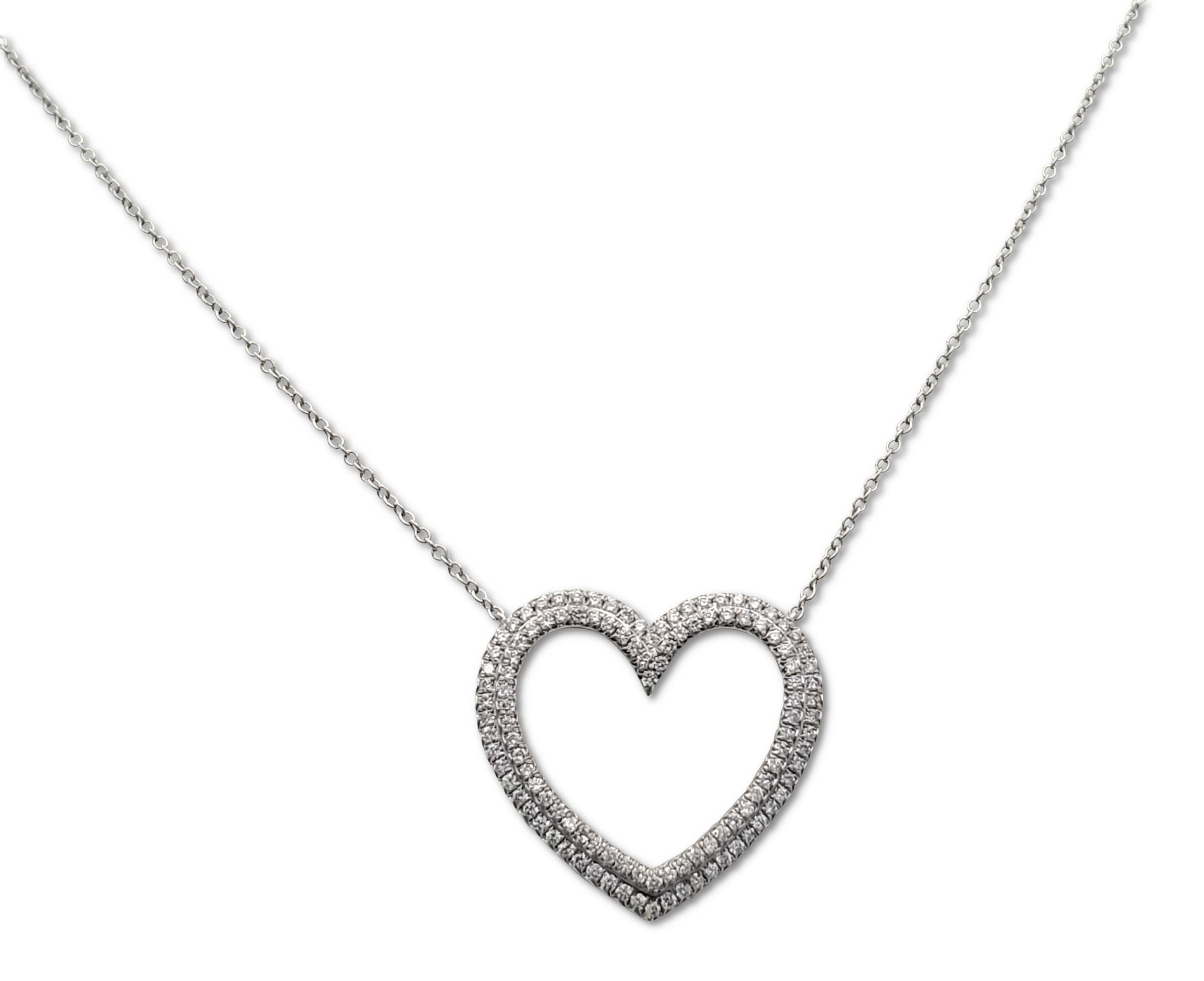 Authentic Tiffany & Co. necklace from the 'Metro' collection centers on a platinum double heart design pendant pave set with an estimated 0.78 carats of high quality round brilliant cut diamonds (E-F color, VS clarity). The pendant is situated on a
