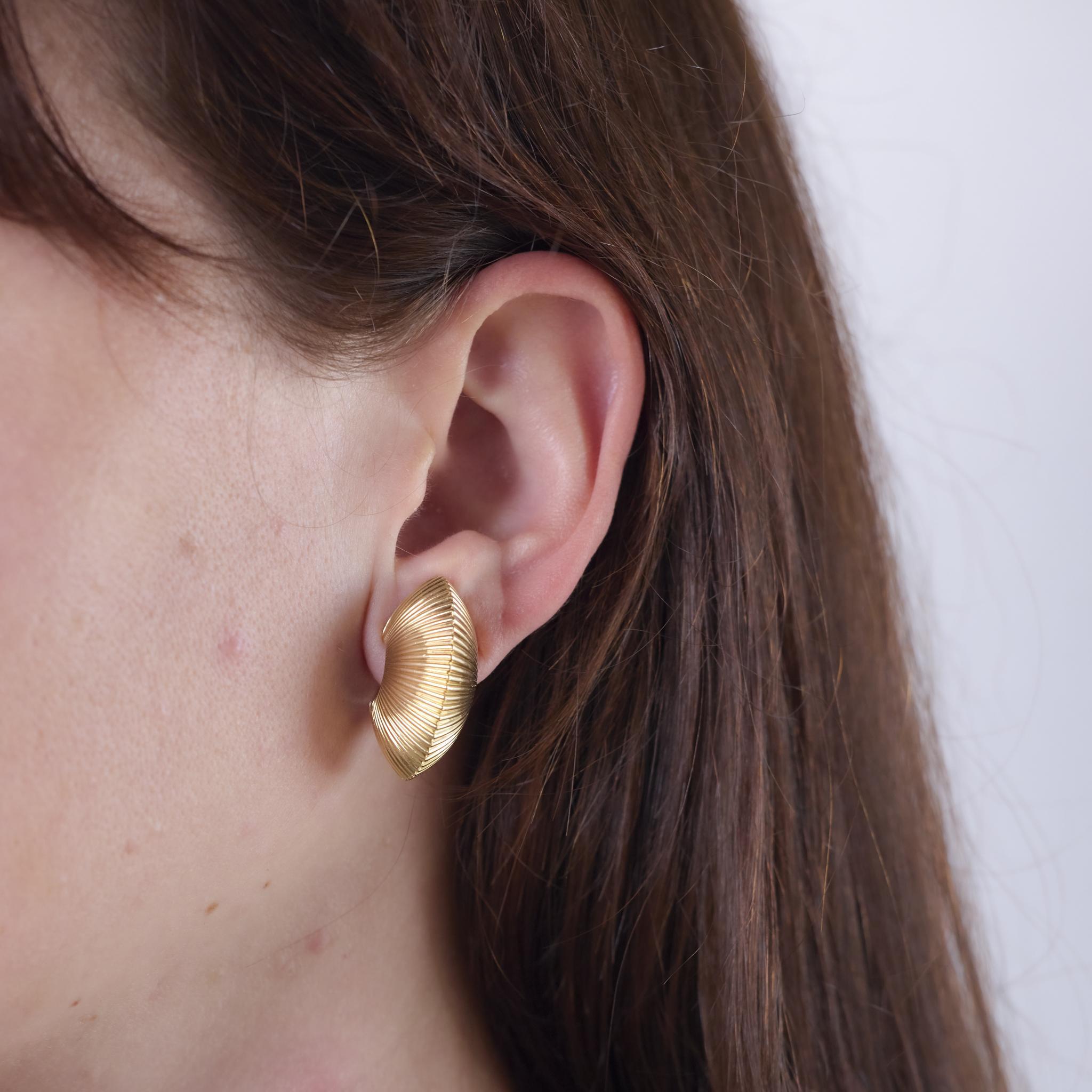 These Mid Century earrings by Tiffany & Co. are crafted in 14k yellow gold and reflect the brand's timeless elegance and refined craftsmanship. Created in the 1950s, they are substantial yet classic in design. Hallmarked with the Tiffany & Co.