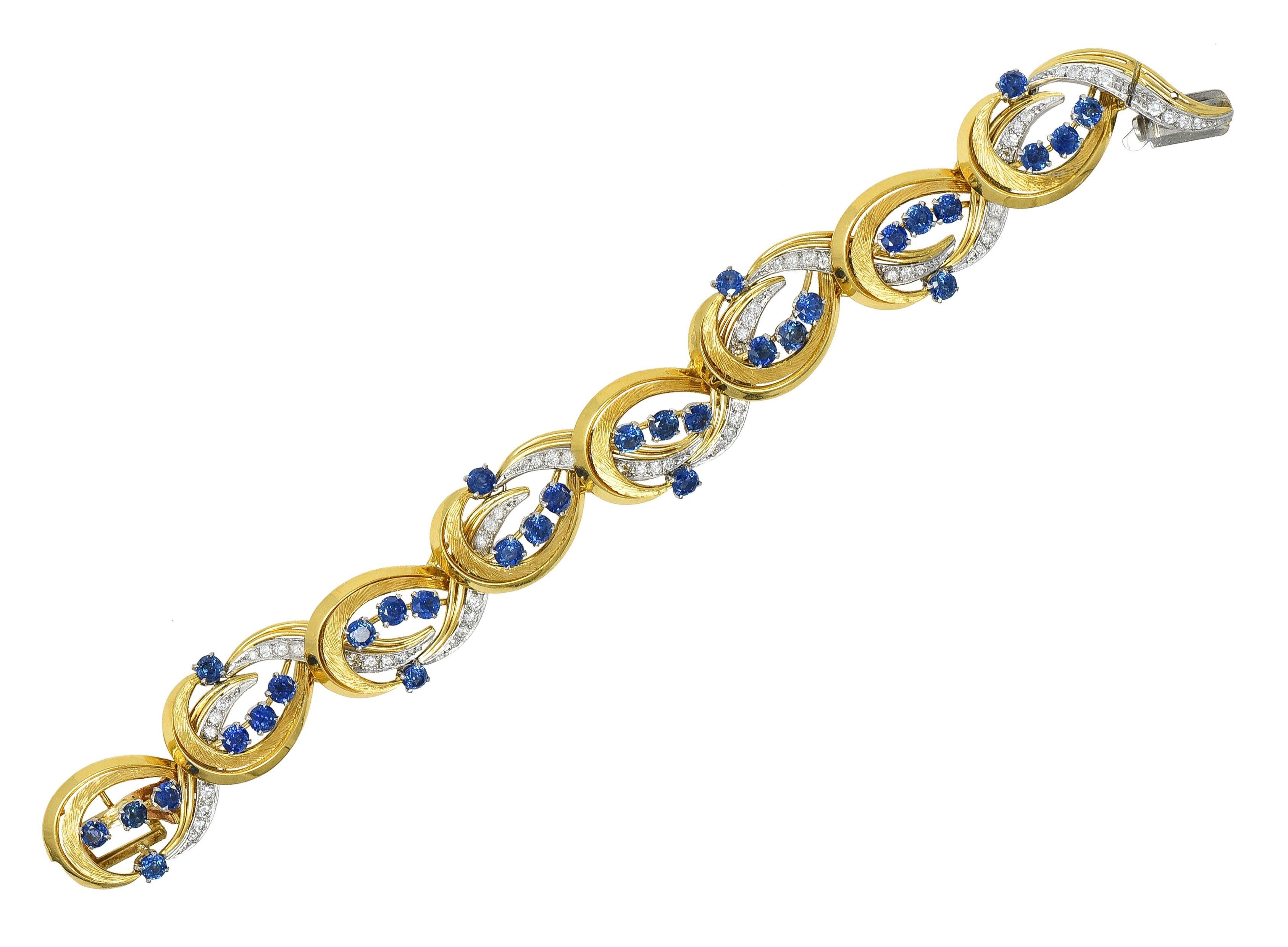 Comprised of hinged links with dimensional yellow gold and platinum scrolls accented by engraved texture
Featuring round cut sapphires throughout weighing approximately 7.20 carats total 
Transparent medium blue and prong set in platinum
With round