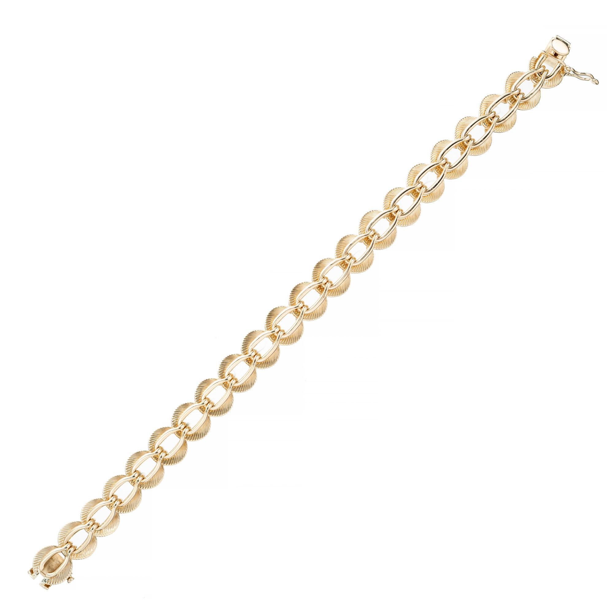 Vintage 1960's solid 14k yellow gold fancy link bracelet by Tiffany & Co.. This mid-century timeless design, features a series of intricate and interlocking oval fancy links, with fan design, that creates a captivating visual effect. Each link is