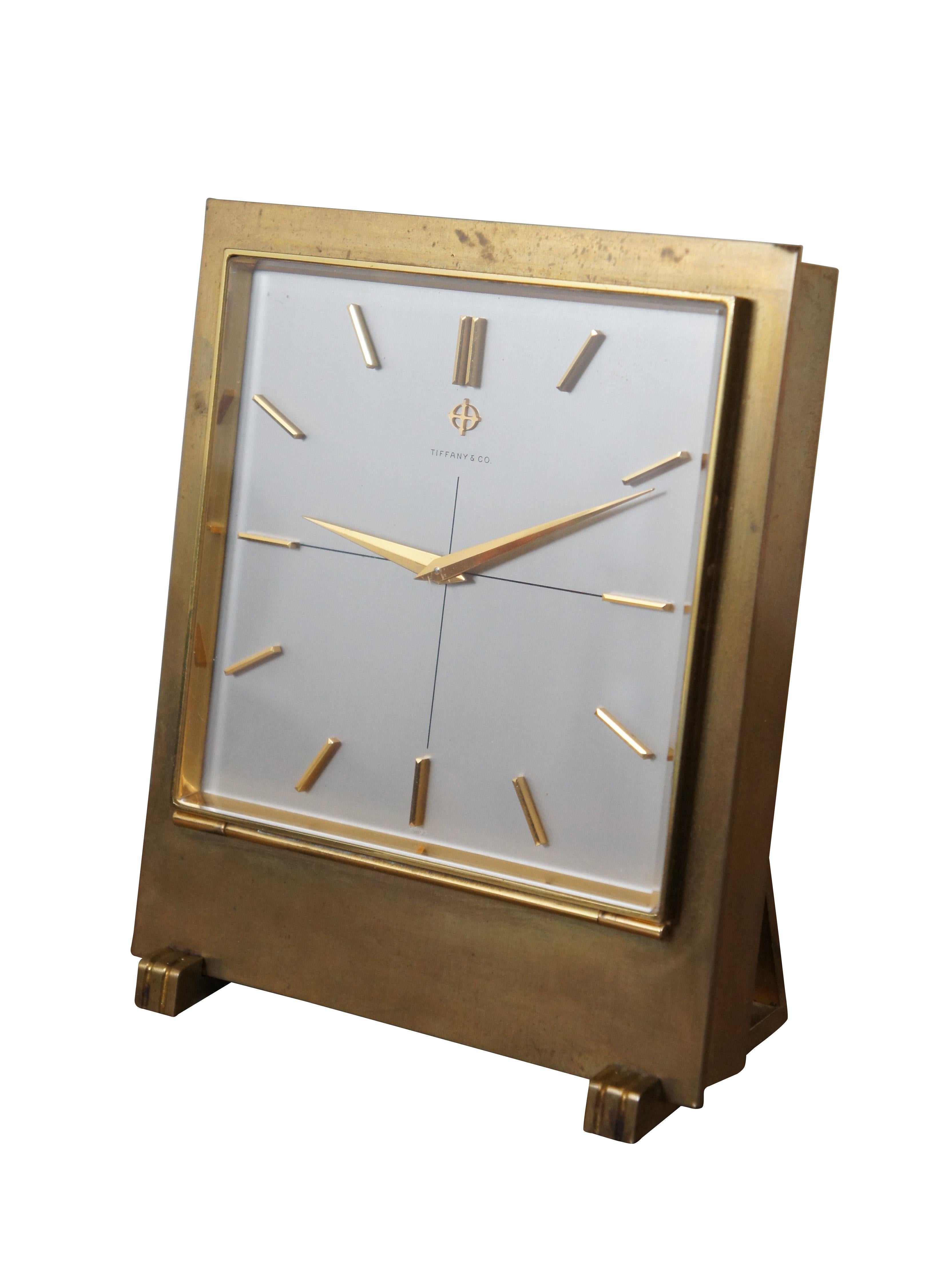 Mid century Tiffany & Company gilt metal battery operated desk clock featuring a rectangular form with art deco feet and hands, and minimalist dashes representing the numbers. Manufactured by Zodiac Limited. 15 Jewel Swiss works. Reference Number
