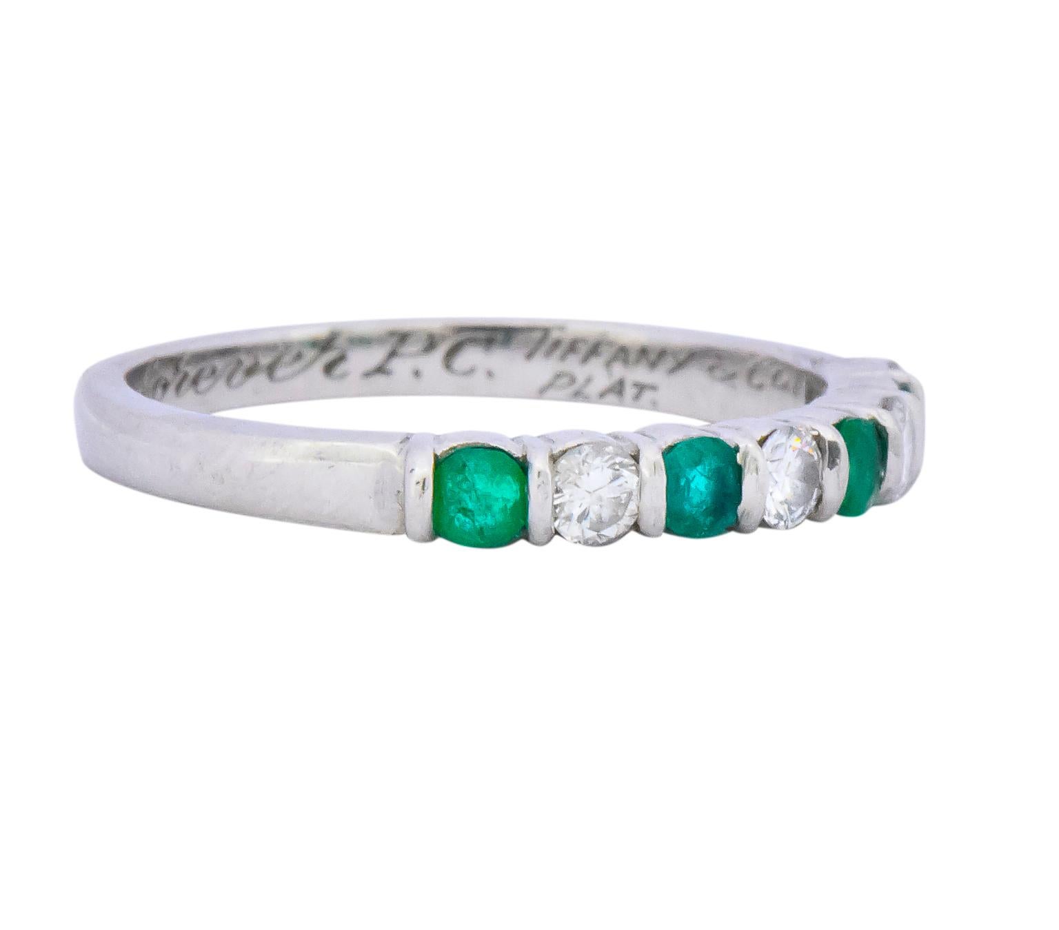 Set to the front with alternating bar set emeralds and round brilliant cut diamonds weighing approximately 0.24 carat total

Emeralds are translucent with a vivid green color and the round brilliant diamonds are G/H color and VS clarity

Inner shank