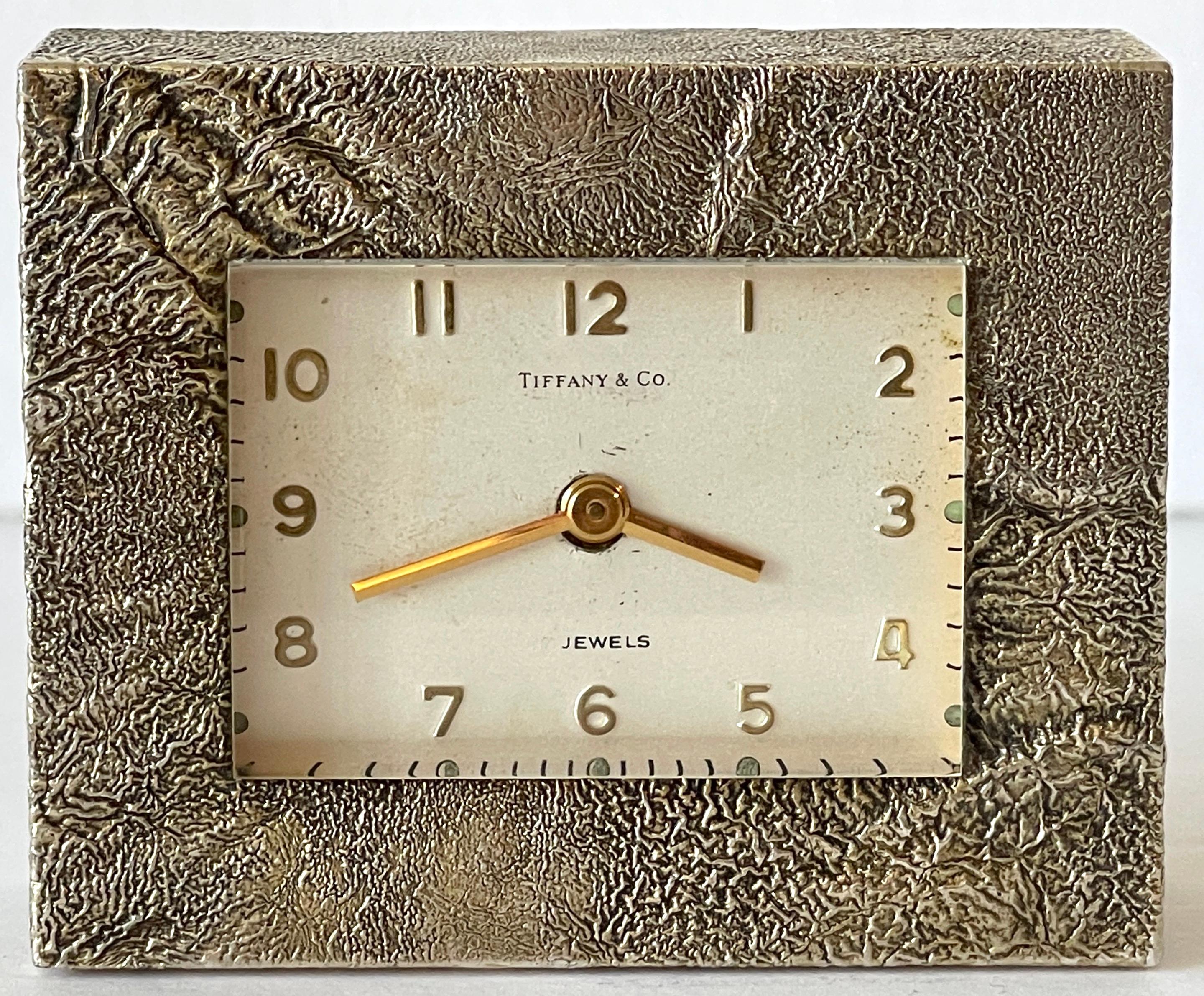 Tiffany & Co. Modern cast bronze 'rockwork' table clock, Swiss jeweled movement.
Switzerland, Circa 1960s 

A stunning example of 1960s Tiffany & Co. modern design. This work, a cast rockwork bronze case, highlighted with silver and gold plating.