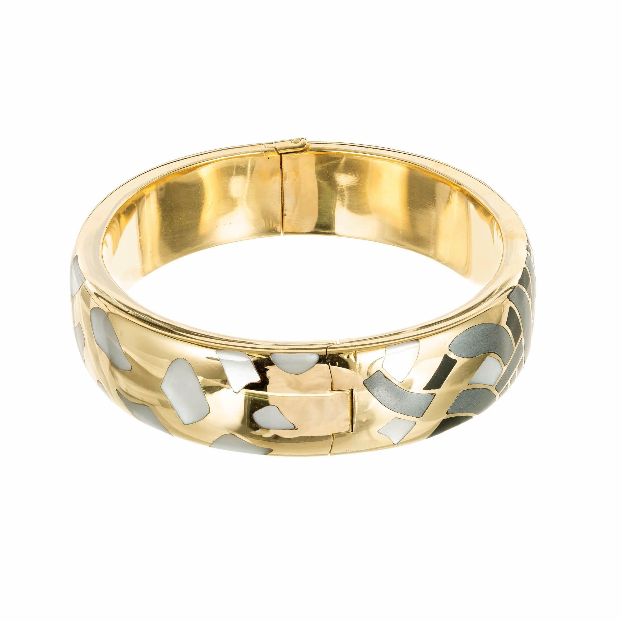 Tiffany & Co Inlaid hinged bangle bracelet, mother of pearl, hematite and black jade in 18k yellow gold. Secure catch and side lock safety. Circa 1980.

Mother of Pearl
Hematite
Black Jade 
18k Yellow Gold 
Stamped: 18KT 
Hallmark: T + Co
44