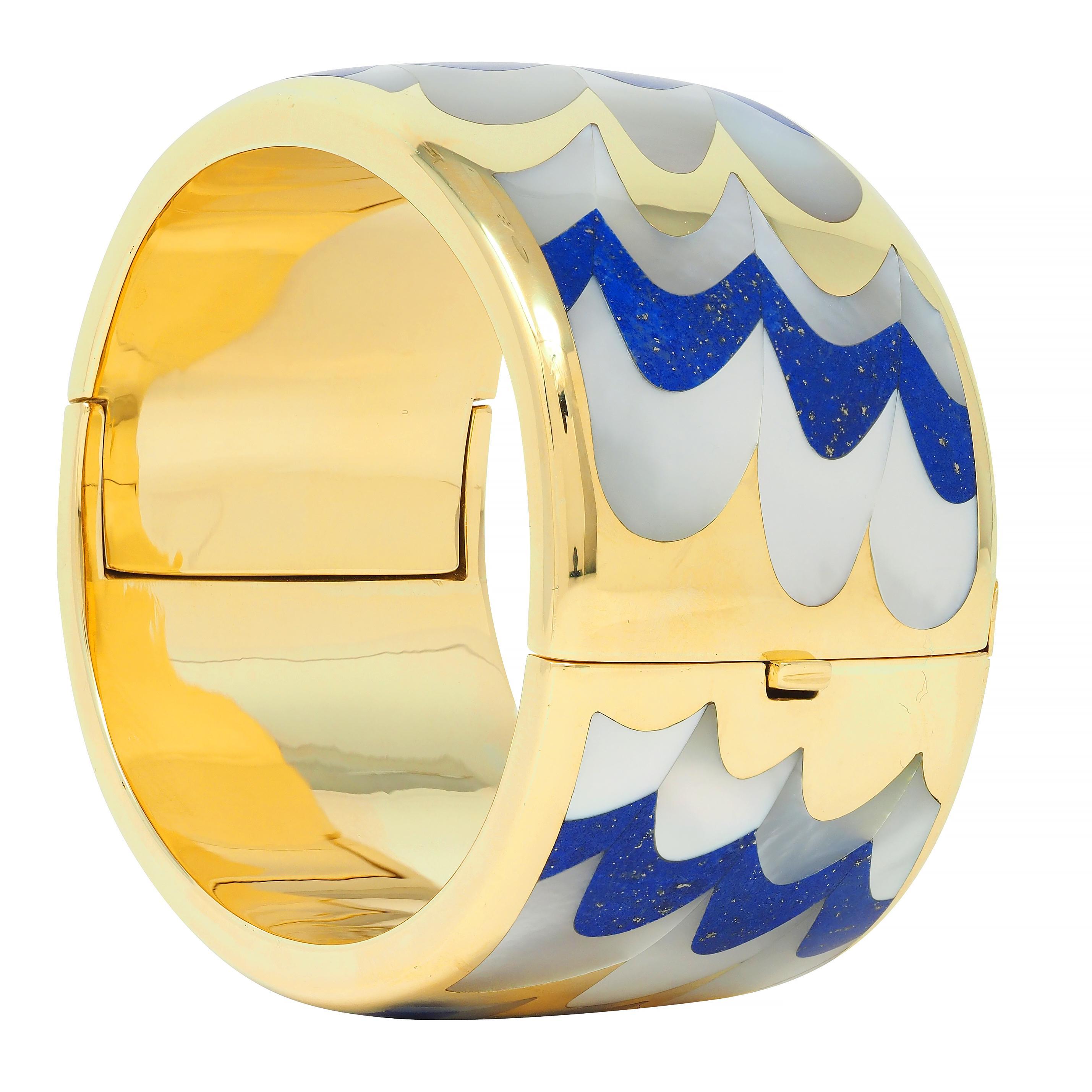 Designed as a wide bangle bracelet with curved surface with an inlaid scallop motif pattern
Featuring lapis lazuli and mother-of-pearl alternating in pattern 
Lapis is opaque ultramarine blue with moderate pyrite flecking 
Mother-of-pearl is white