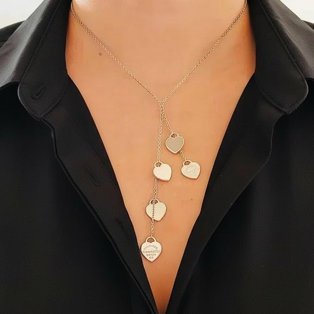 Eleganza romantica con questa incantevole Tiffany & Co. Multi-Heart Lariat Necklace, un capolavoro che cattura l'essenza dell'amore e della raffinatezza. Questo splendido pezzo presenta diversi delicati charme a forma di cuore che scendono a cascata