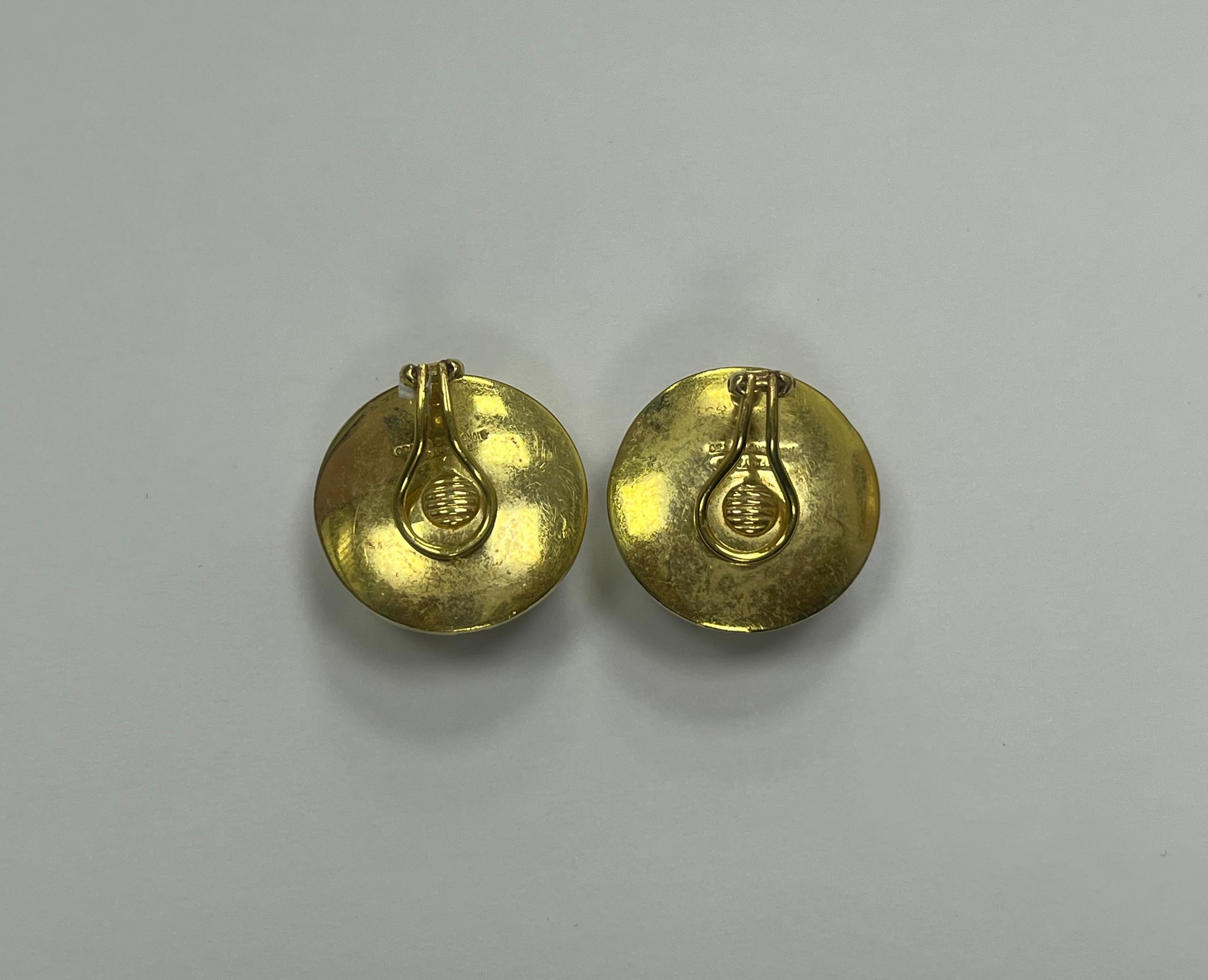 A Paired set of Tiffany & Co. Mother-of-Pearl, Black Onyx, 18k Yellow Gold Ear Clips  
Each Featuring Mother-of-Pearl and Black onyx inlay in a checkered motif, set in an 18k yellow gold domed non-pierced ear clip mounting  
Measuring :