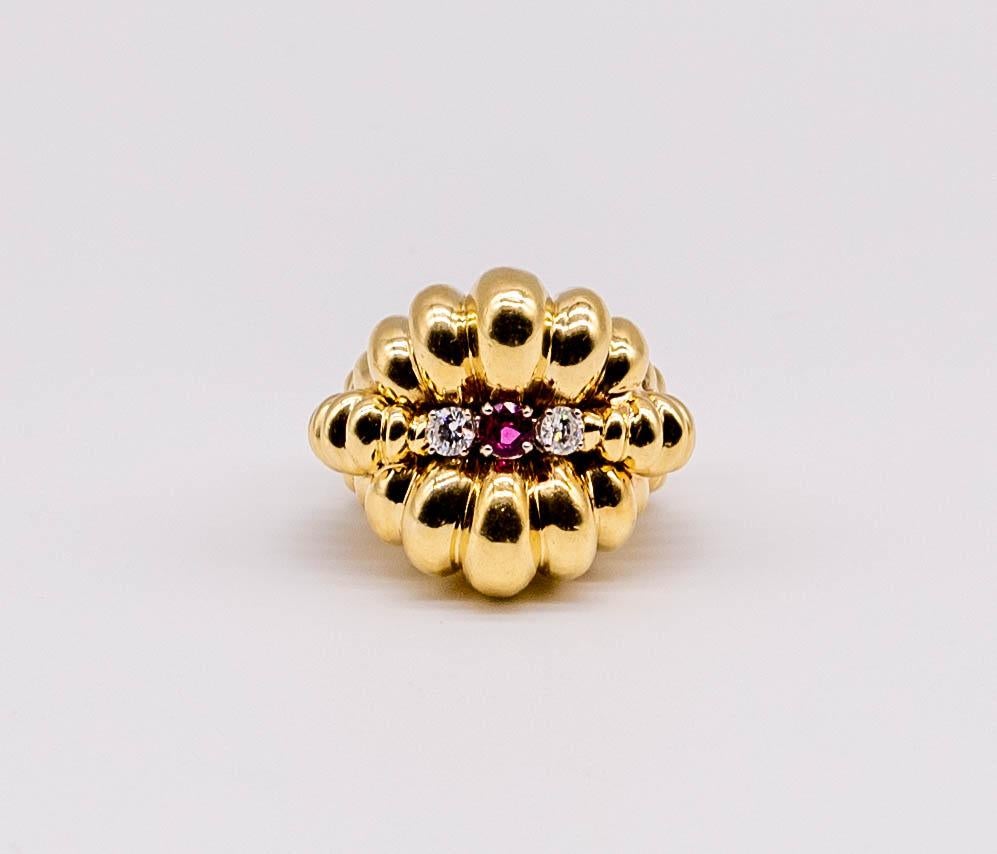 A strong statement piece, this distinctive ring consists of geometrically placed domes of 18 karat yellow gold centering a round ruby flanked by round diamonds.  The ring is a wearable size 6 1/4, and the round ruby weighs about 1/2 carat.  (we do