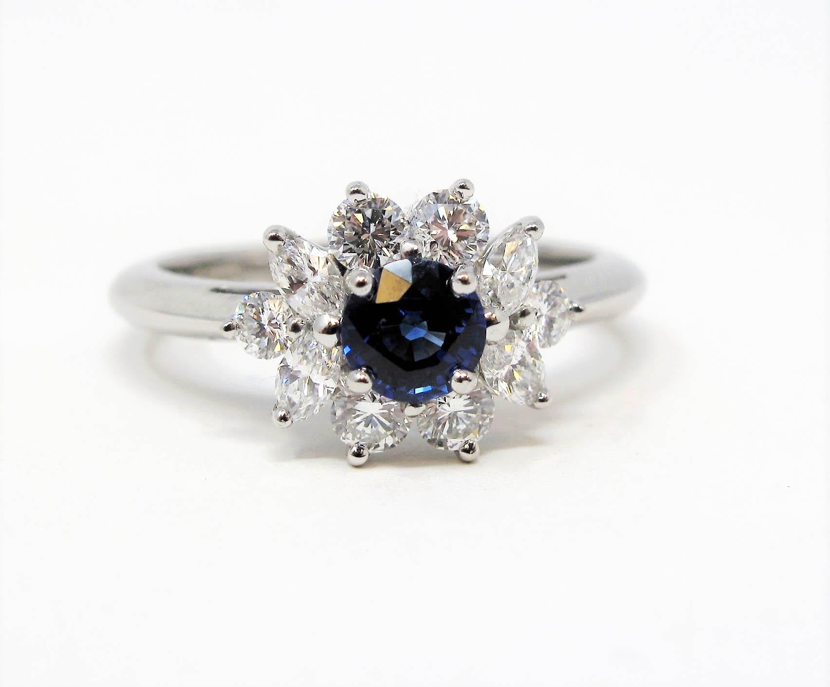 Absolutely radiant natural sapphire and diamond halo ring from esteemed jeweler, Tiffany & Co.. The vivid blue center stone is paired with a glittering halo of bright white diamonds, allowing this beautiful, feminine piece to sparkle spectacularly