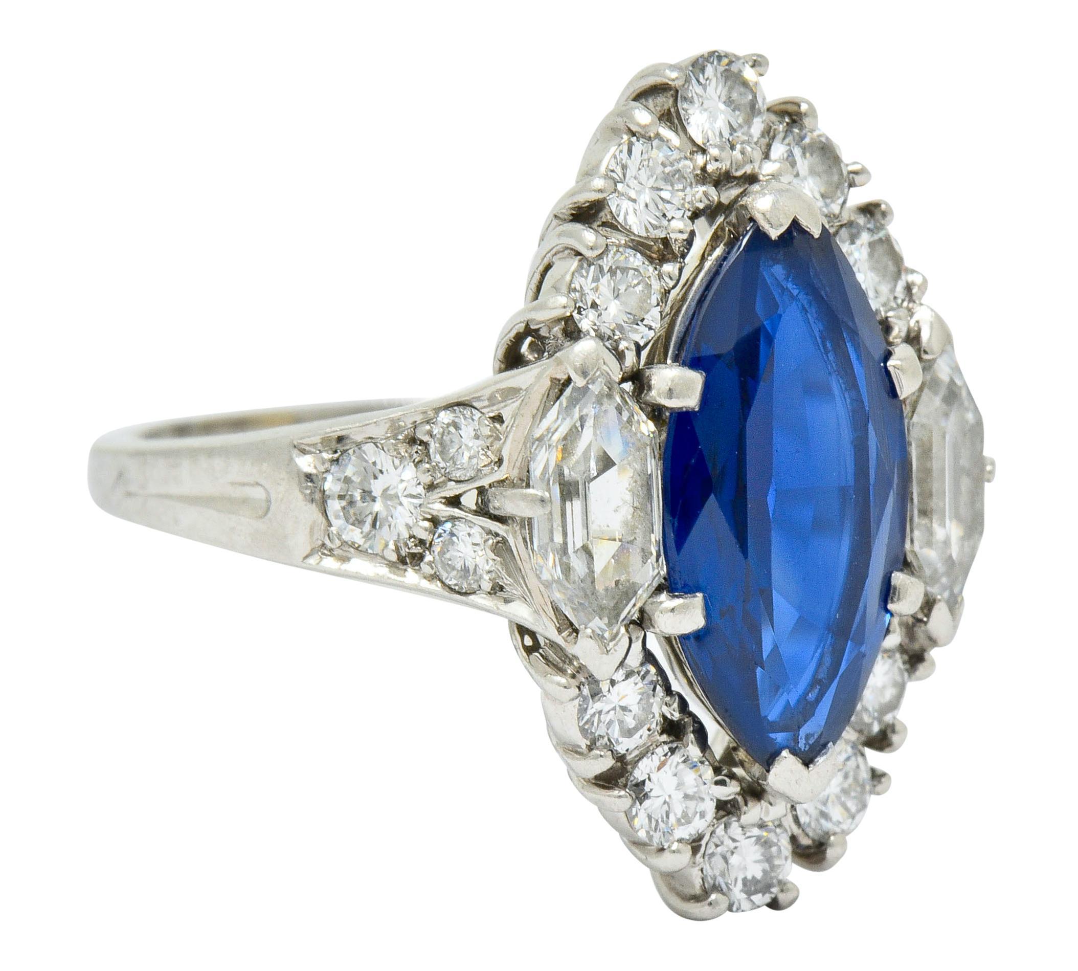 Centering a marquis mixed cut sapphire weighing approximately 2.00 carats

Transparent and deeply royal blue with no indications of heat

Flanked by two hexagonal step cut diamonds weighing in total approximately 0.50 carat; G/H color with VVS
