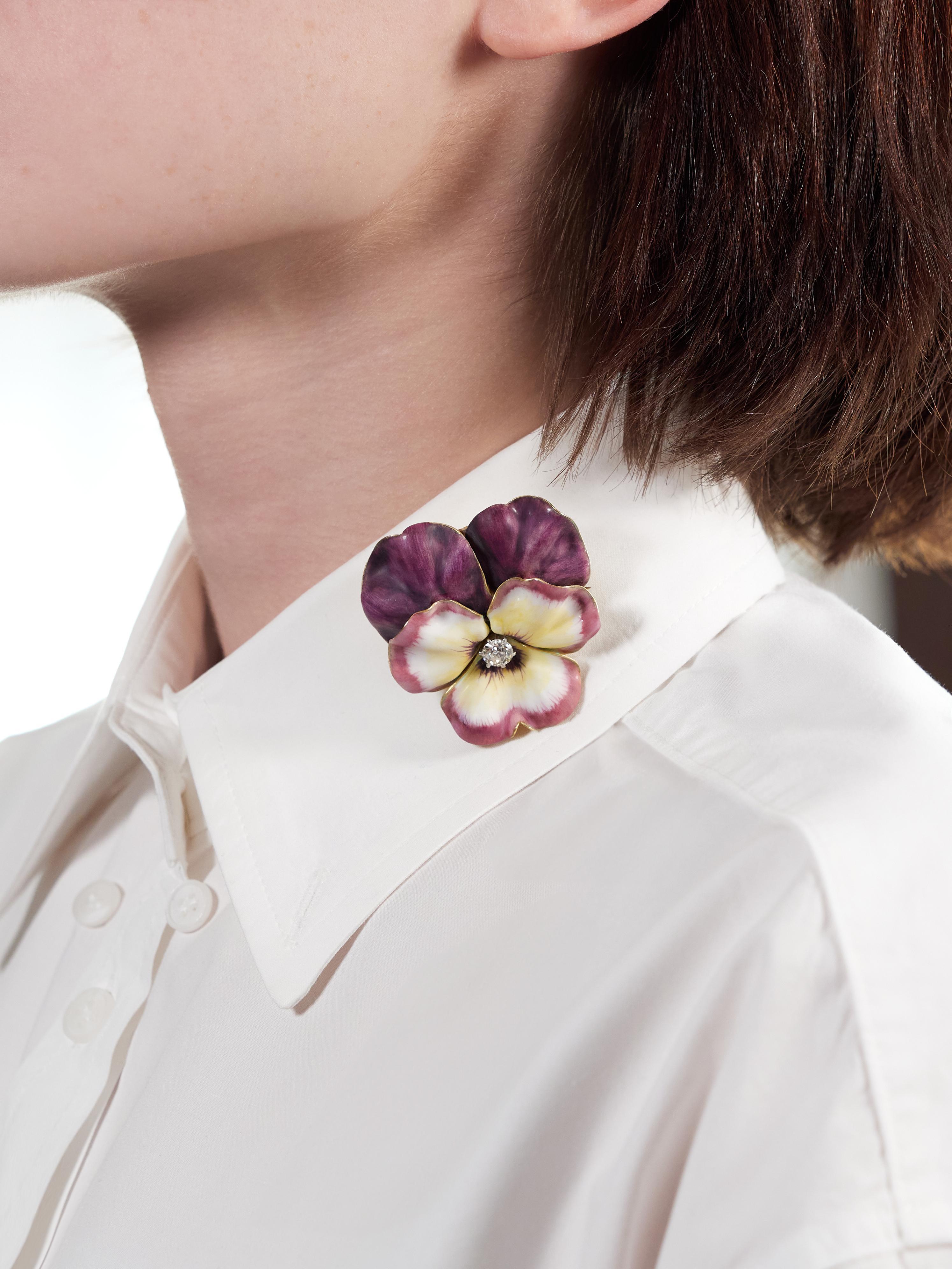 Designed as a dimensional pansy flower painted with basse-taille enamel
Transparent white, purple, and yellow glossed over linear engraving
Exhibiting minimal loss and centering an old mine cut diamond
Weighing approximately 0.60 carat total - H