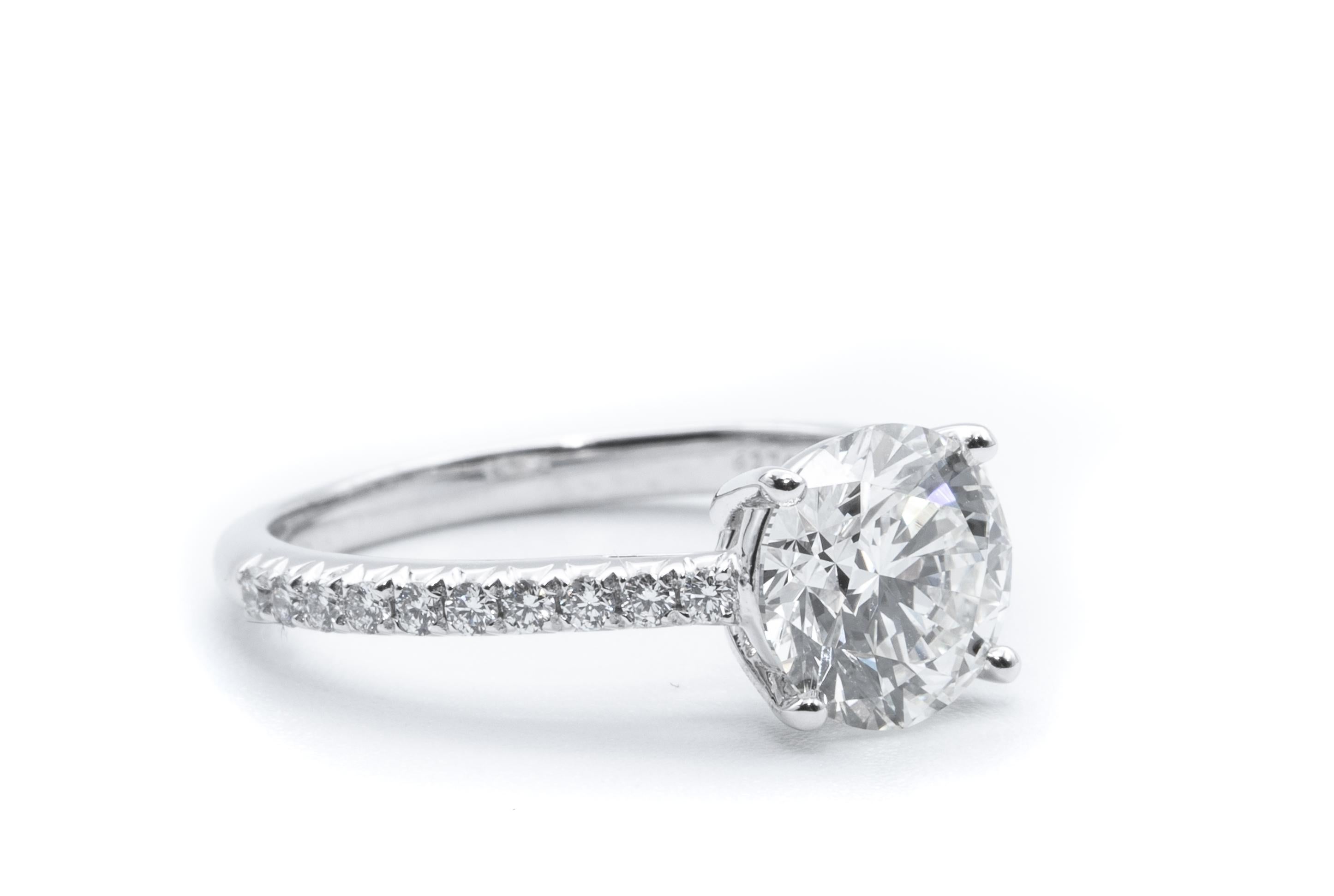 Tiffany & Co Diamond Engagement Solitaire signed by Tiffany & Co. featuring a 1.56 carat Center, graded I Color , and VS2 Clarity.
Highlighted with 20 brilliant cut round diamonds
With original papers.
Diamond Crown inscription :  T&Co