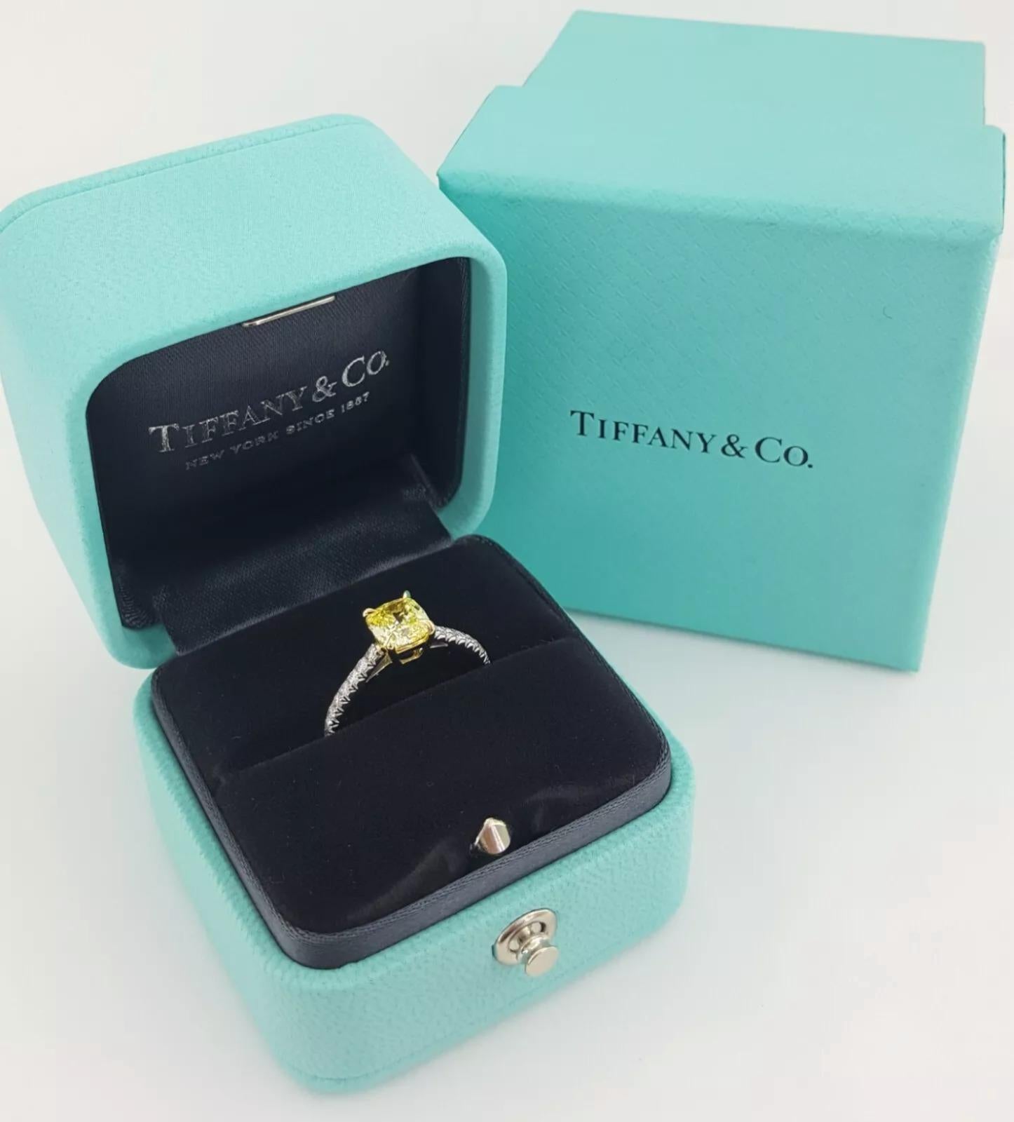 Tiffany & Co. NOVO Platinum Fancy Intense Yellow Diamond Engagement Ring in like-new condition. This timeless piece features the iconic Novo Cushion Brilliant Cut, a signature cut exclusively crafted by Tiffany & Co., known for its exceptional