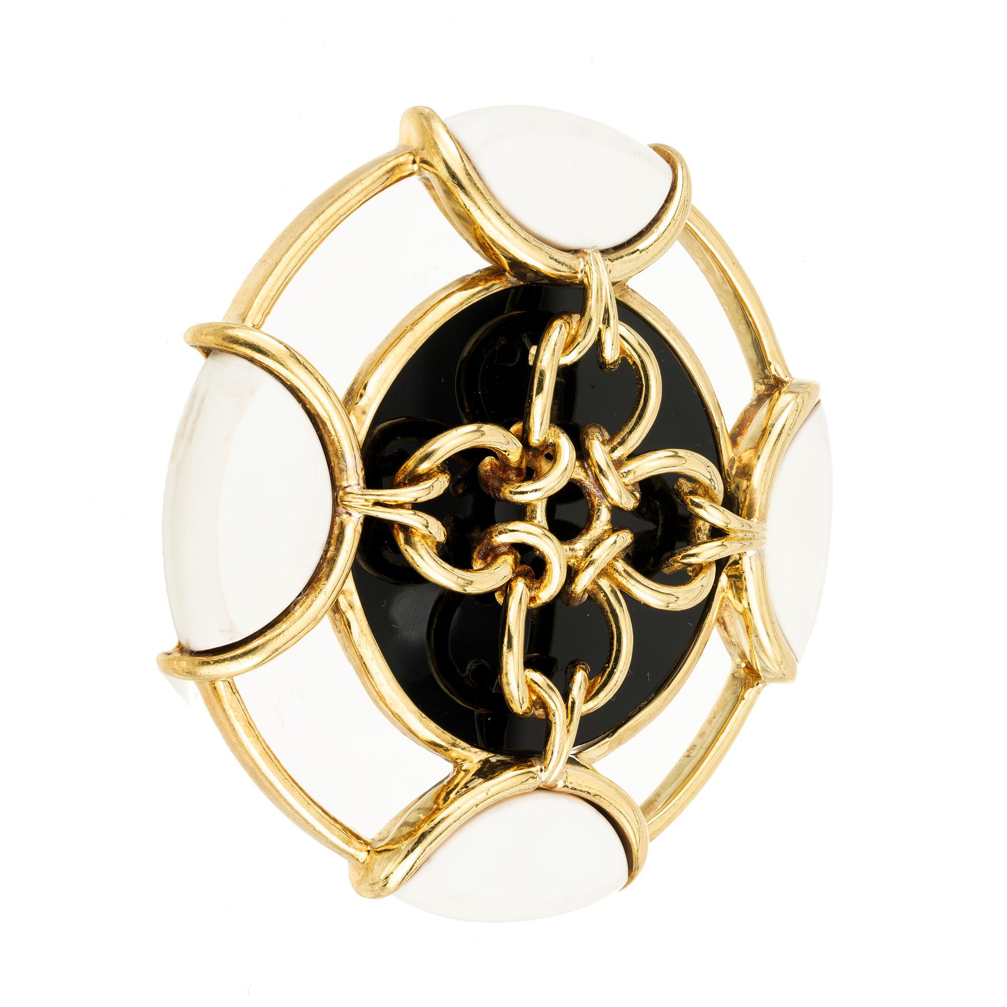 Tiffany & Co. Onyx Pristine gold brooch pendant is a true statement piece that captures the essence of the famed designer. Crafted with impeccable attention to detail, this exquisite pendant features a round onyx stone mounted ibn 18k yellow gold